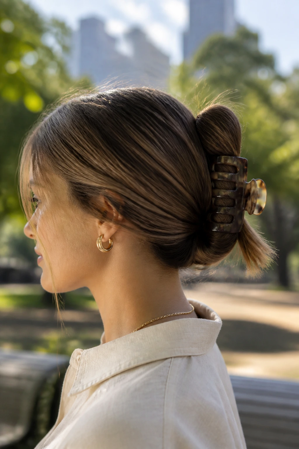 Three-quarter portrait of a real woman with a claw clip twist at the nape.