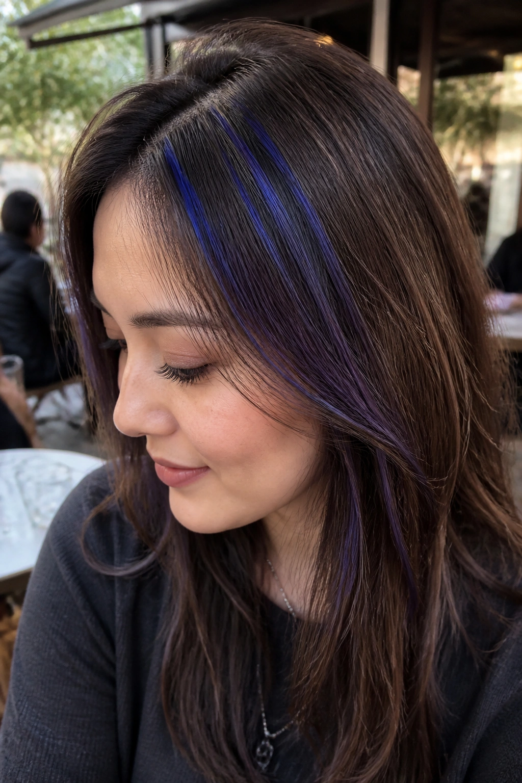 Close-up of a person with tiny cobalt babylights scattered through brown hair.
