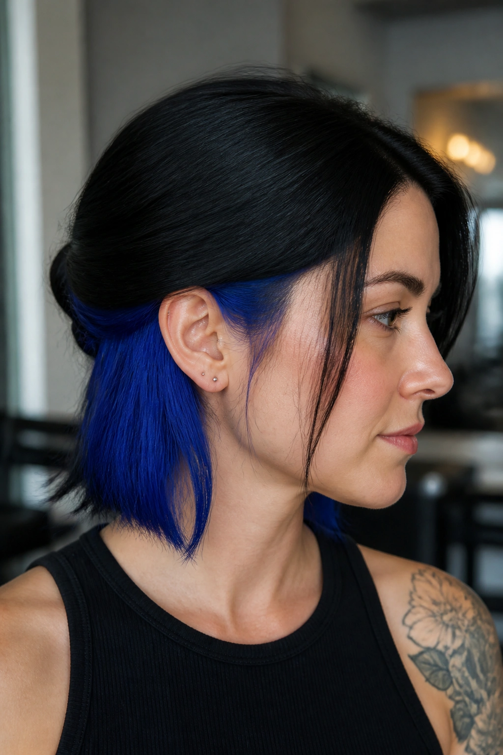 Close-up of a real woman with cobalt peekaboo panels under black hair