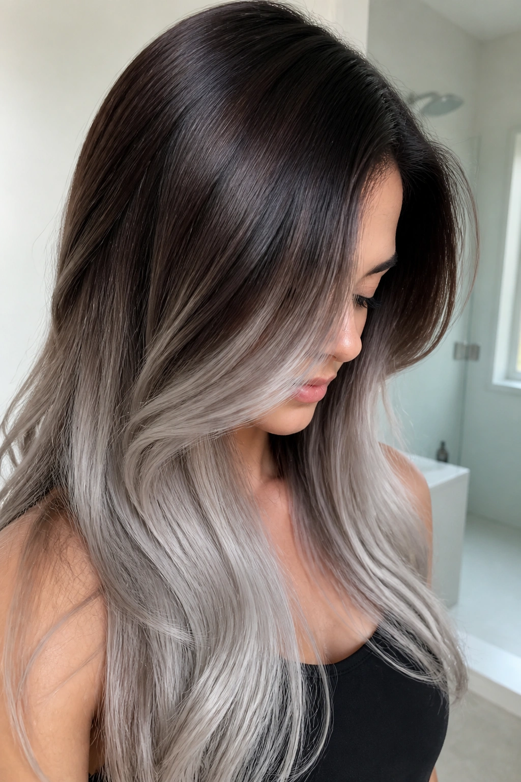 Close-up of glossy cocoa brunette to pearl silver fade on long hair.