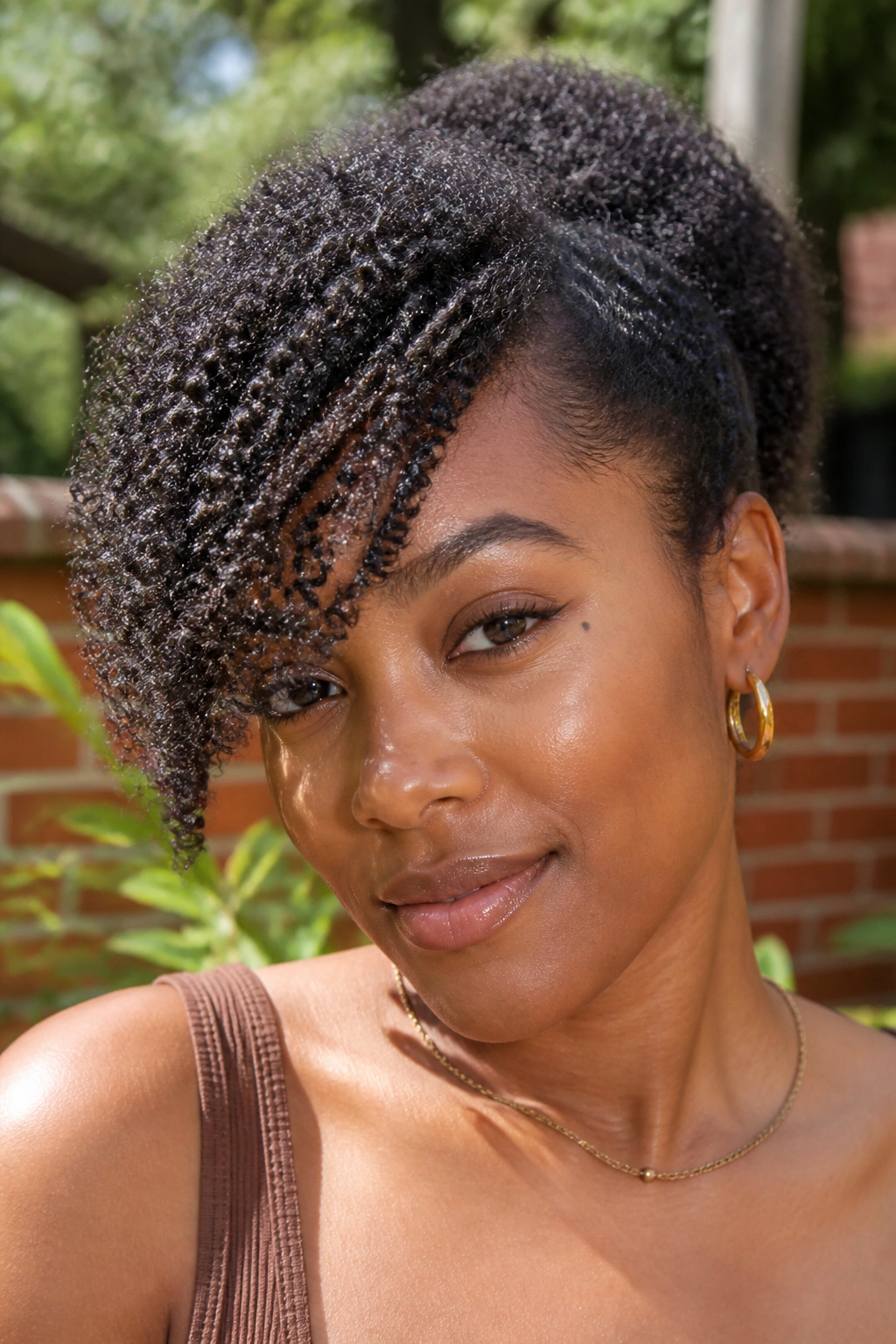 Coily hair with diagonal side bangs showing stretch and shape on a real person