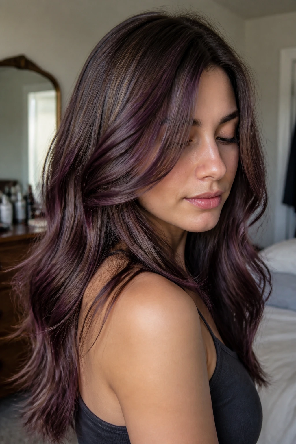 Close-up of a real woman with ash brown hair and cool plum highlights