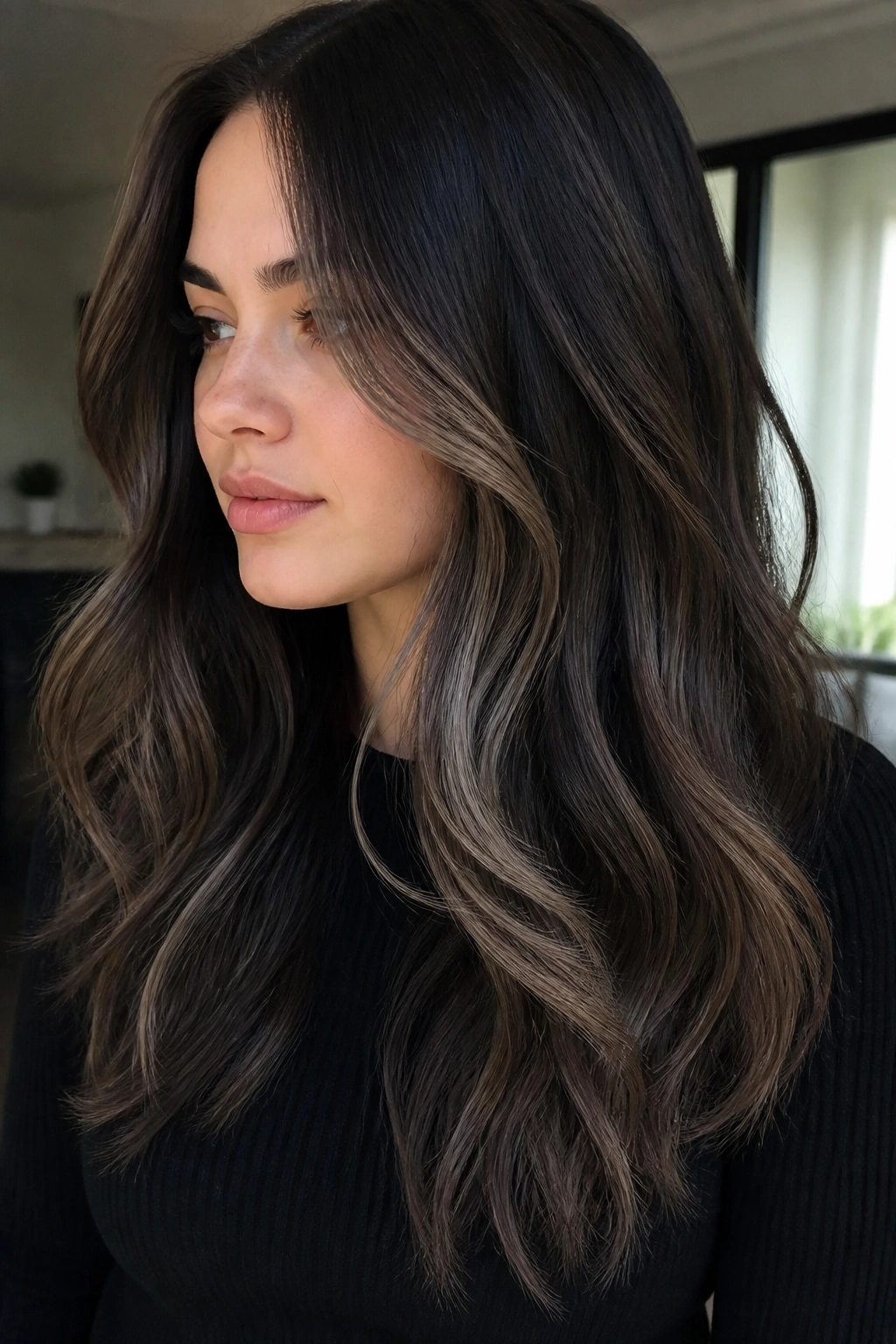 Close-up of a real person with cool taupe highlights on black hair.