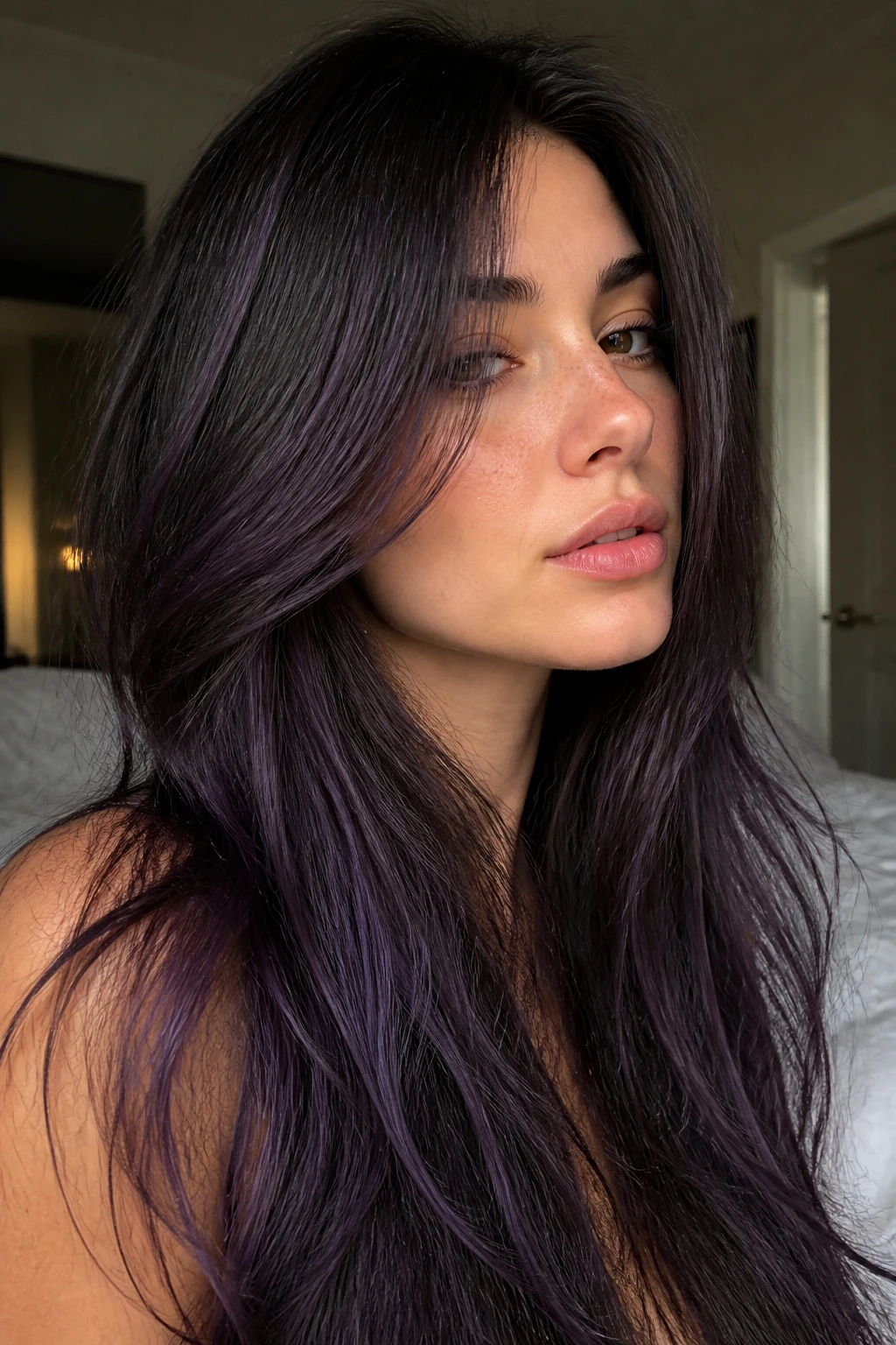 Close-up of a real woman with cool brunette base and violet veil in long layered hair