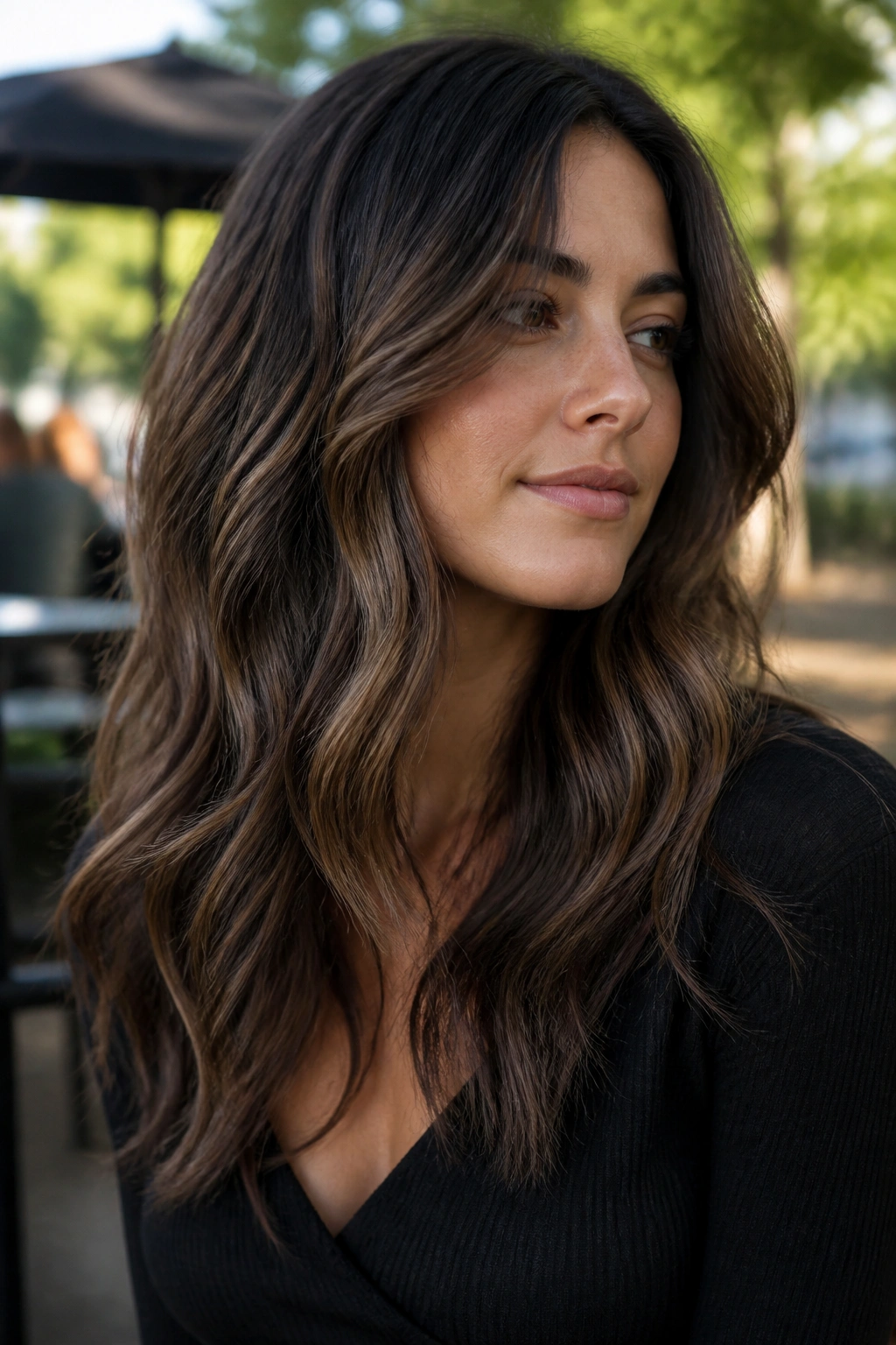 Close-up of real woman with cool walnut balayage and lived-in depth, natural light.