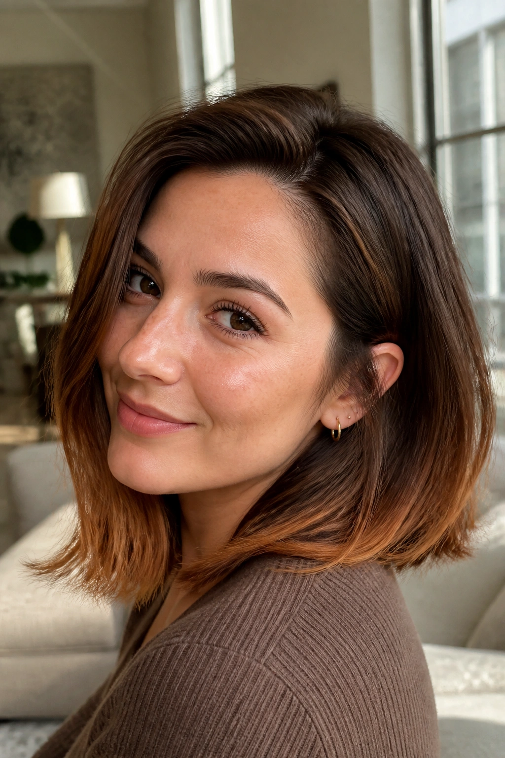 Real woman with copper brown lob and bright ends in warm indoor light
