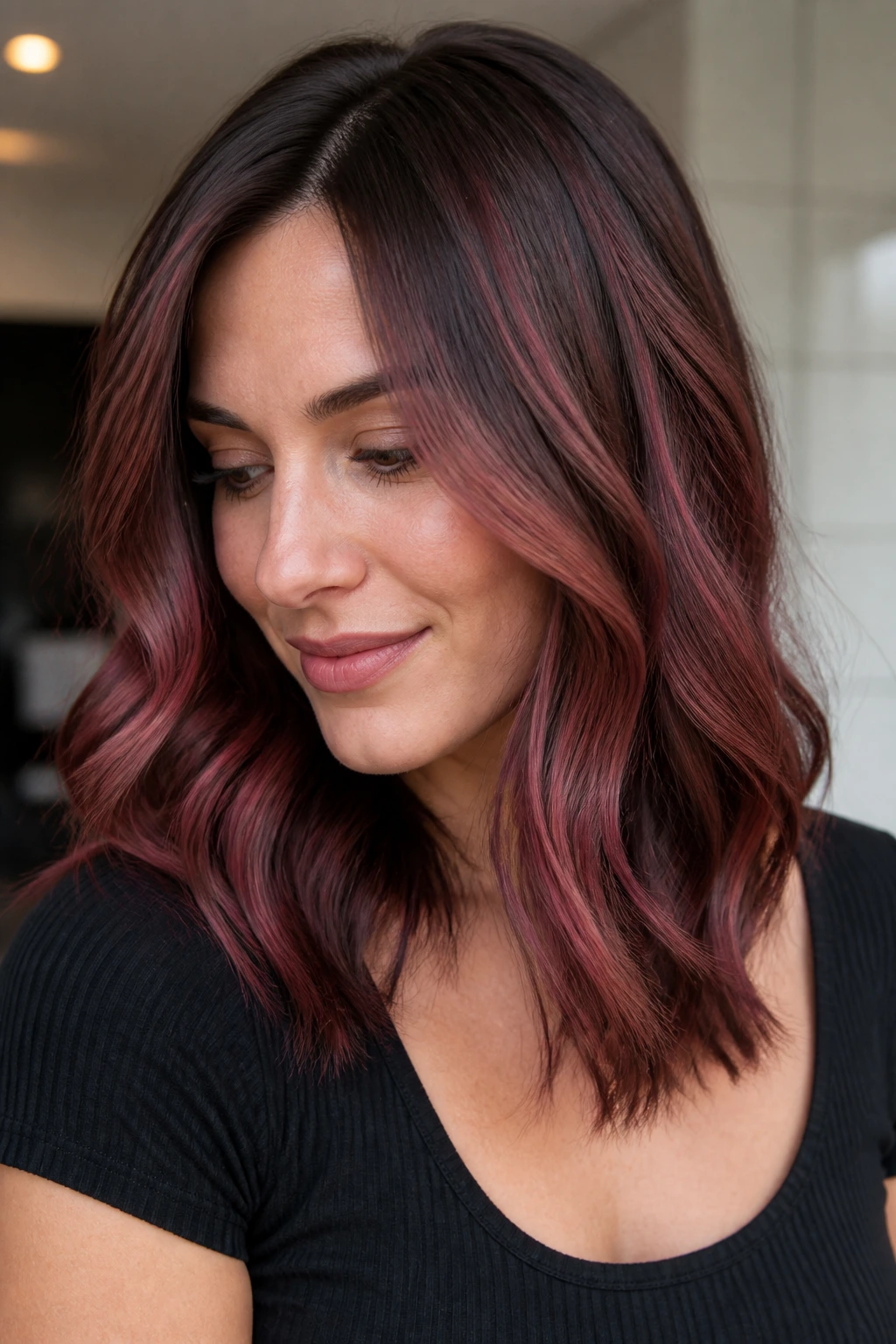 Close-up of a real woman with cranberry balayage on medium brown hair
