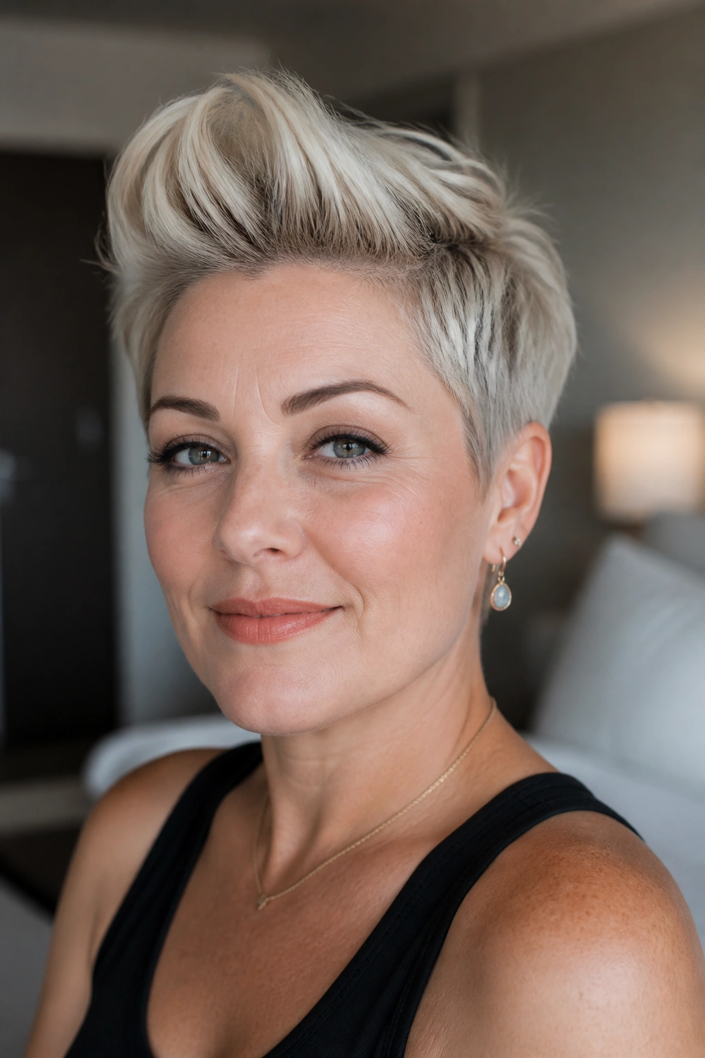 Portrait of a woman with a crown-height blonde pixie cut and lifted top