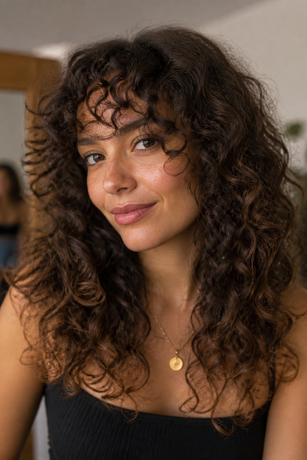 Portrait of a woman with long curly bangs following curl pattern