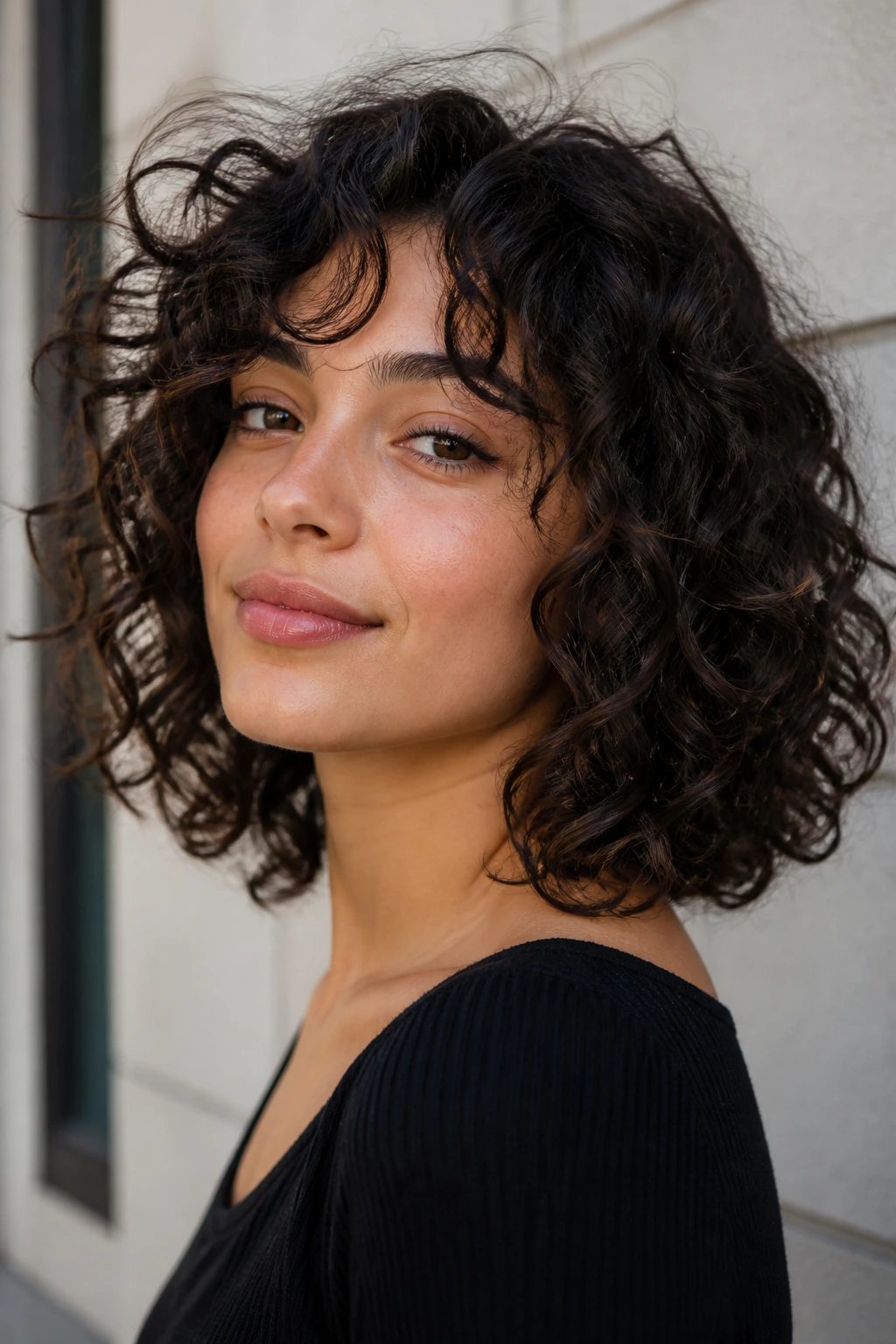 Close-up portrait of a real woman with curly lob texture under natural light