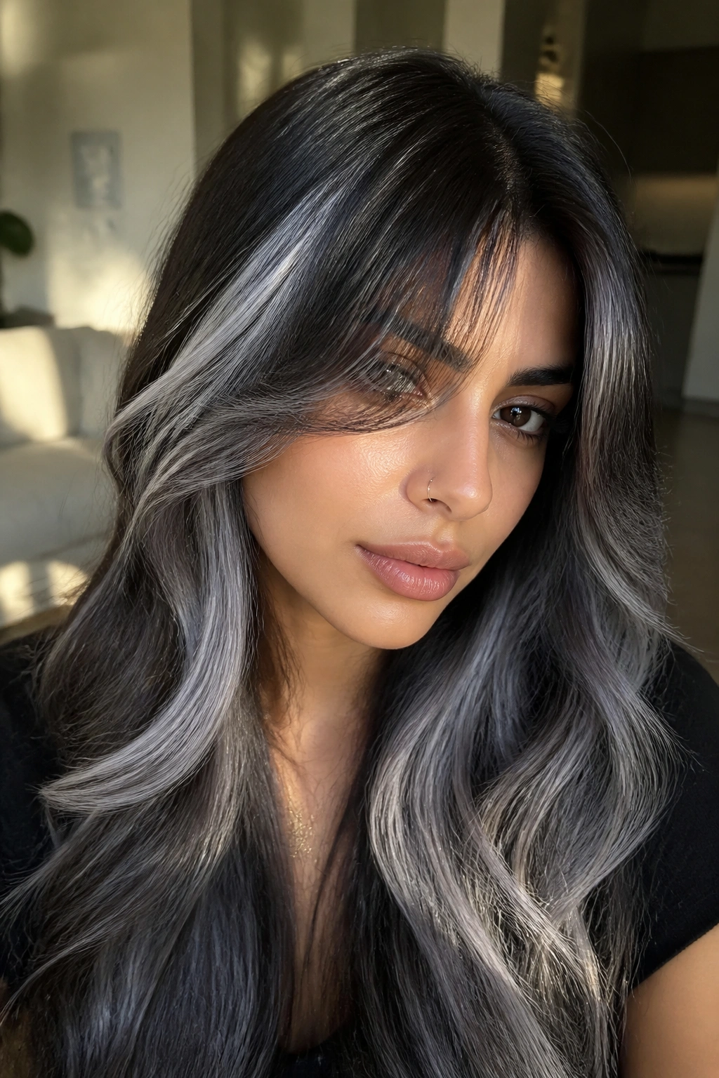 Close-up of a real woman with curtain bangs and black-to-silver ombre framing the face