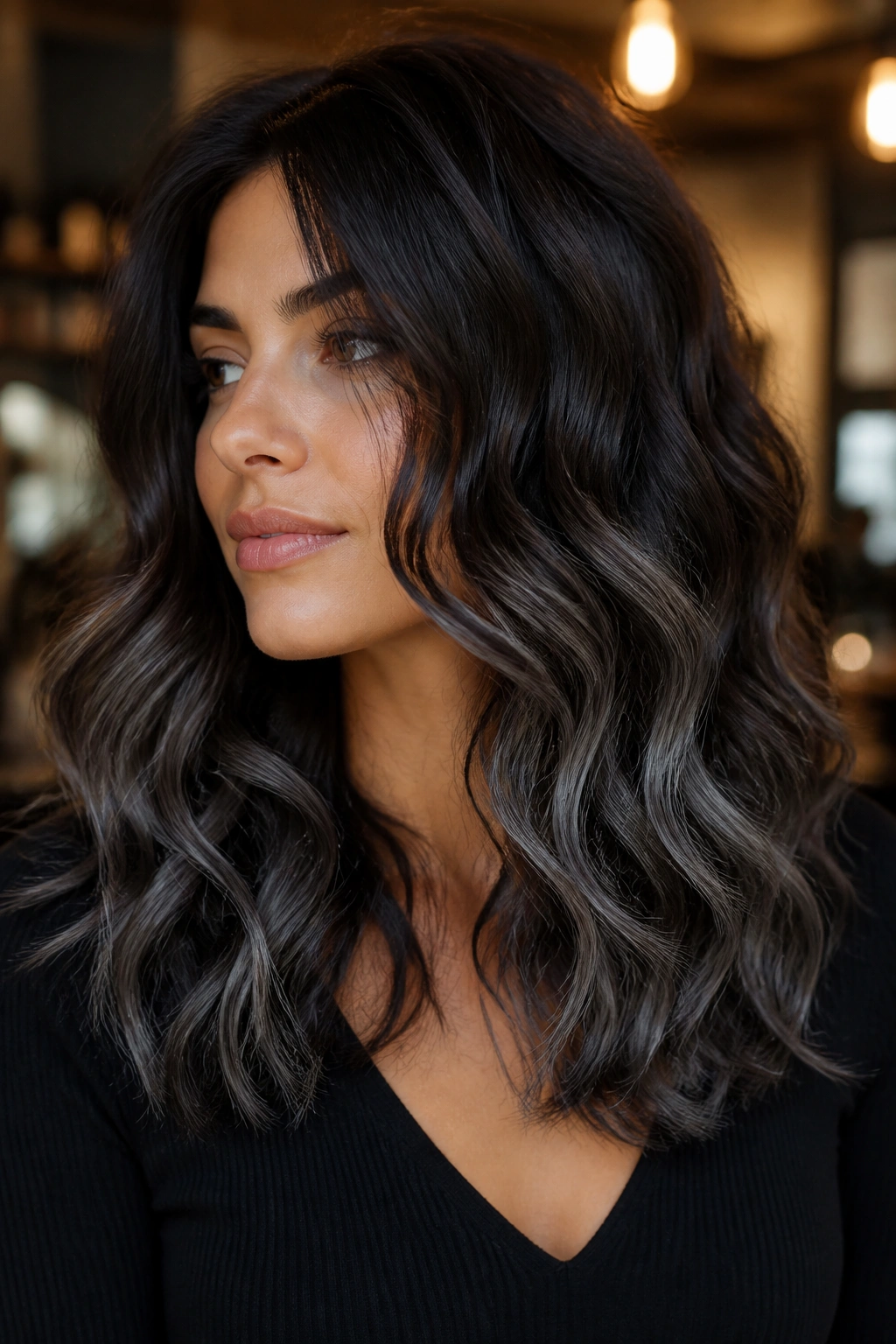 Close-up of a real woman with Dark Chocolate and Slate balayage on curly brown hair