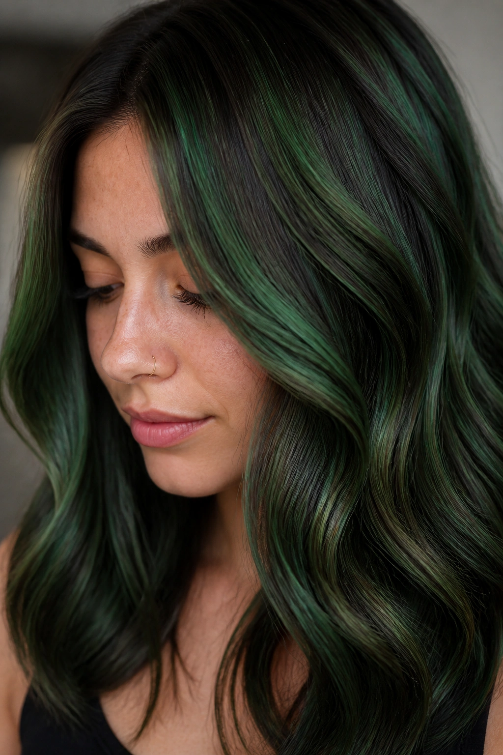Dark green lowlights and bright highlights creating depth on brunette hair