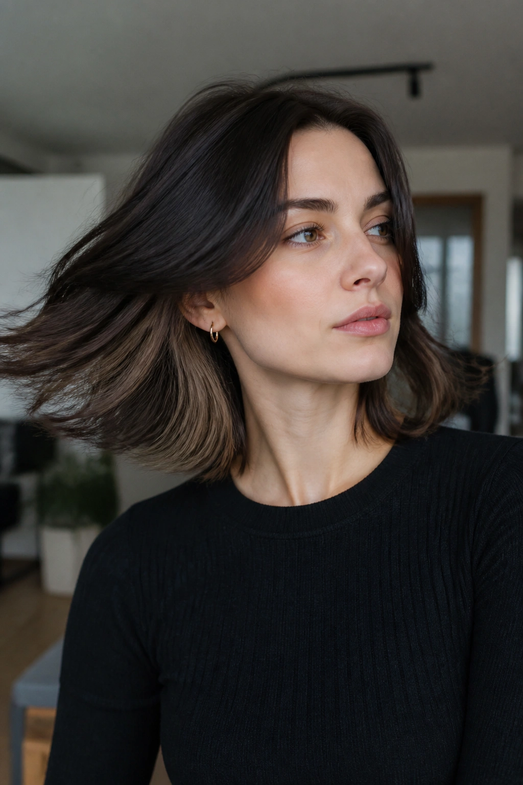 Portrait of a person with dark mocha hair and hidden caramel underlights peeking through