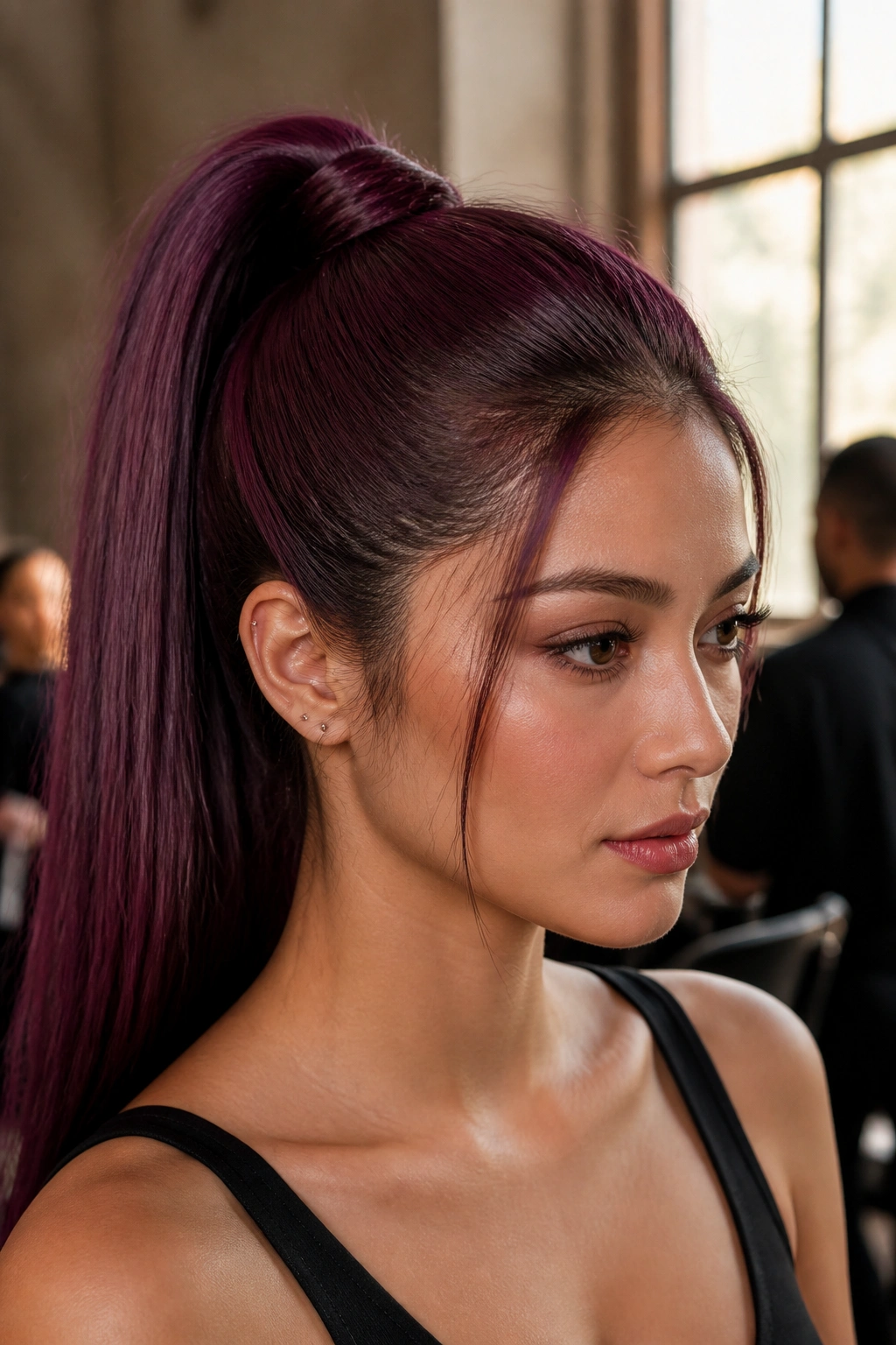 Close-up portrait of a real woman with a deep plum sleek ponytail