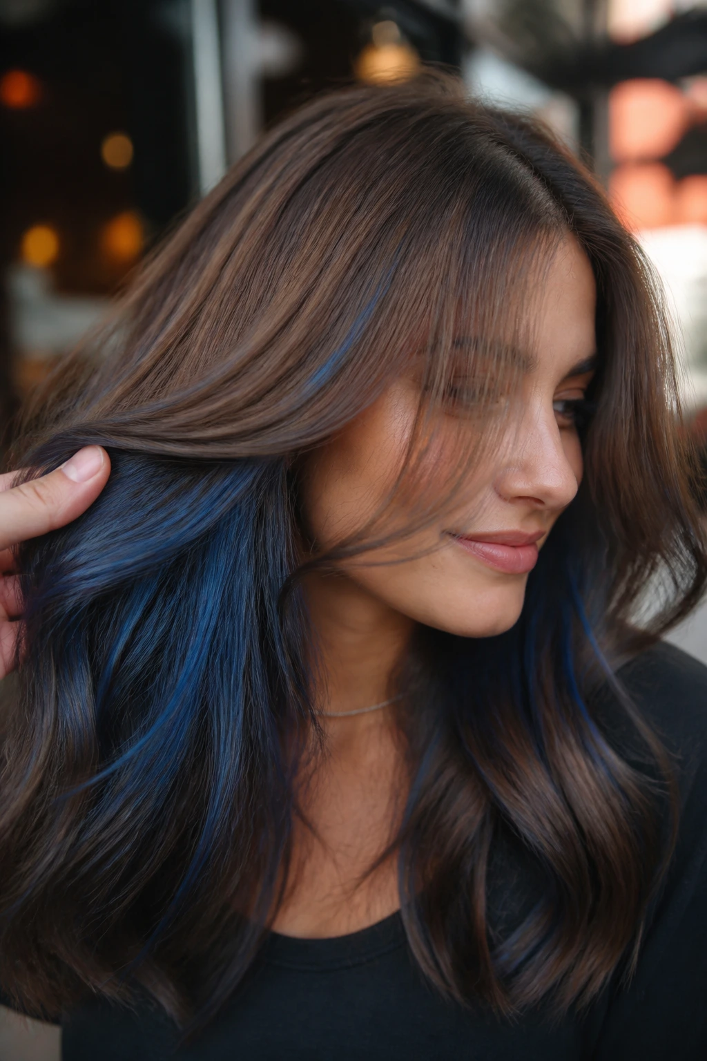 Close-up of medium brown hair with denim blue slices balayage