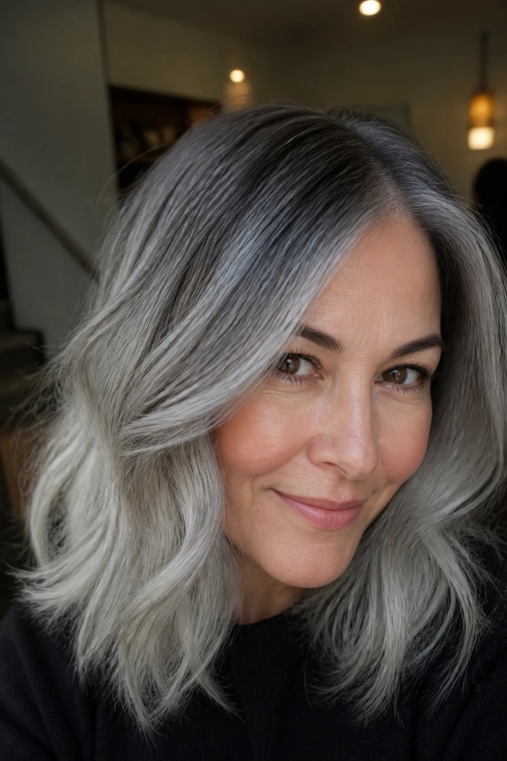 Close-up of a real woman with dim root melt gray hair