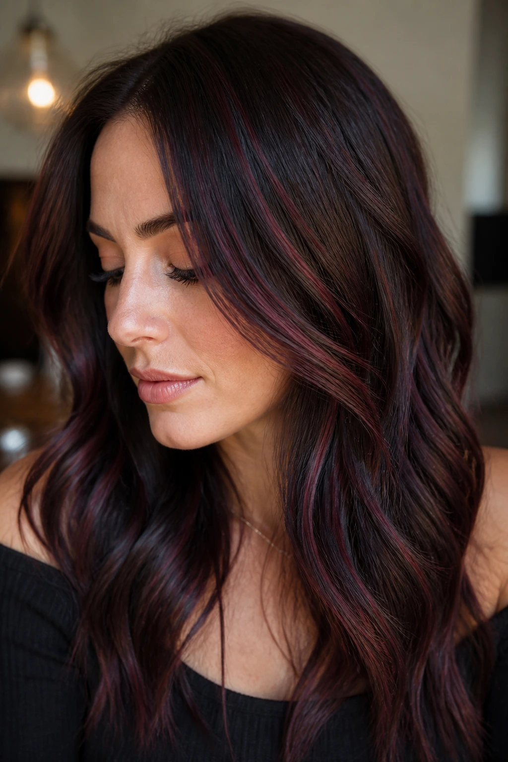 Portrait of brunette with dimensional mahogany babylights and cool undertones.