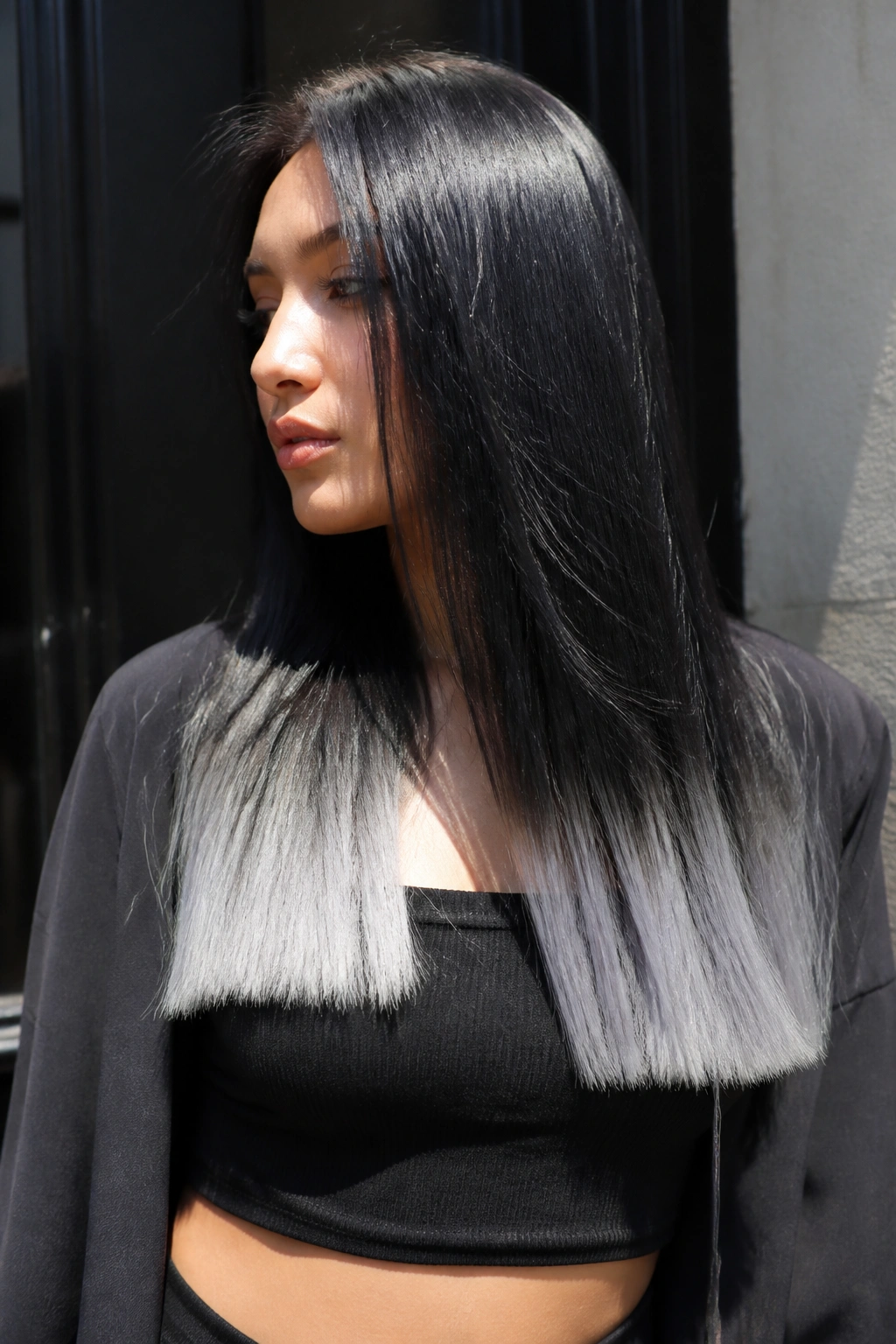 Close-up of long hair with sharp dip-dyed silver ends in bright outdoor light