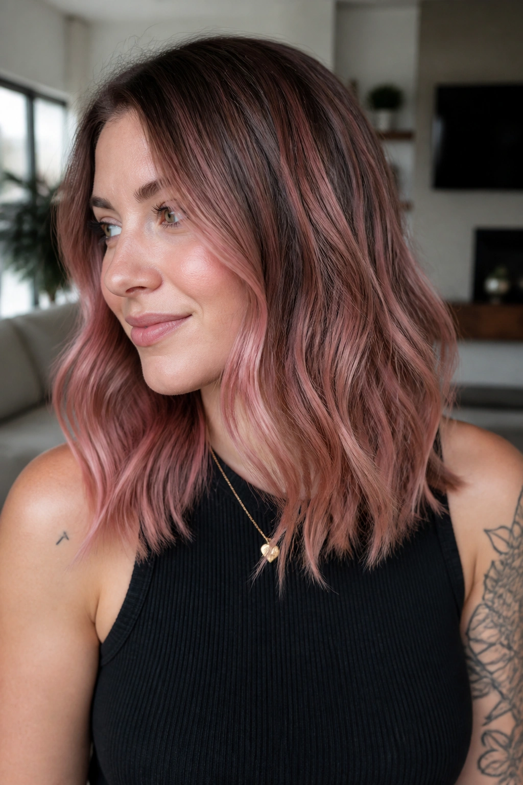 Close-up portrait of a real woman with dusty rose balayage hair in natural daylight