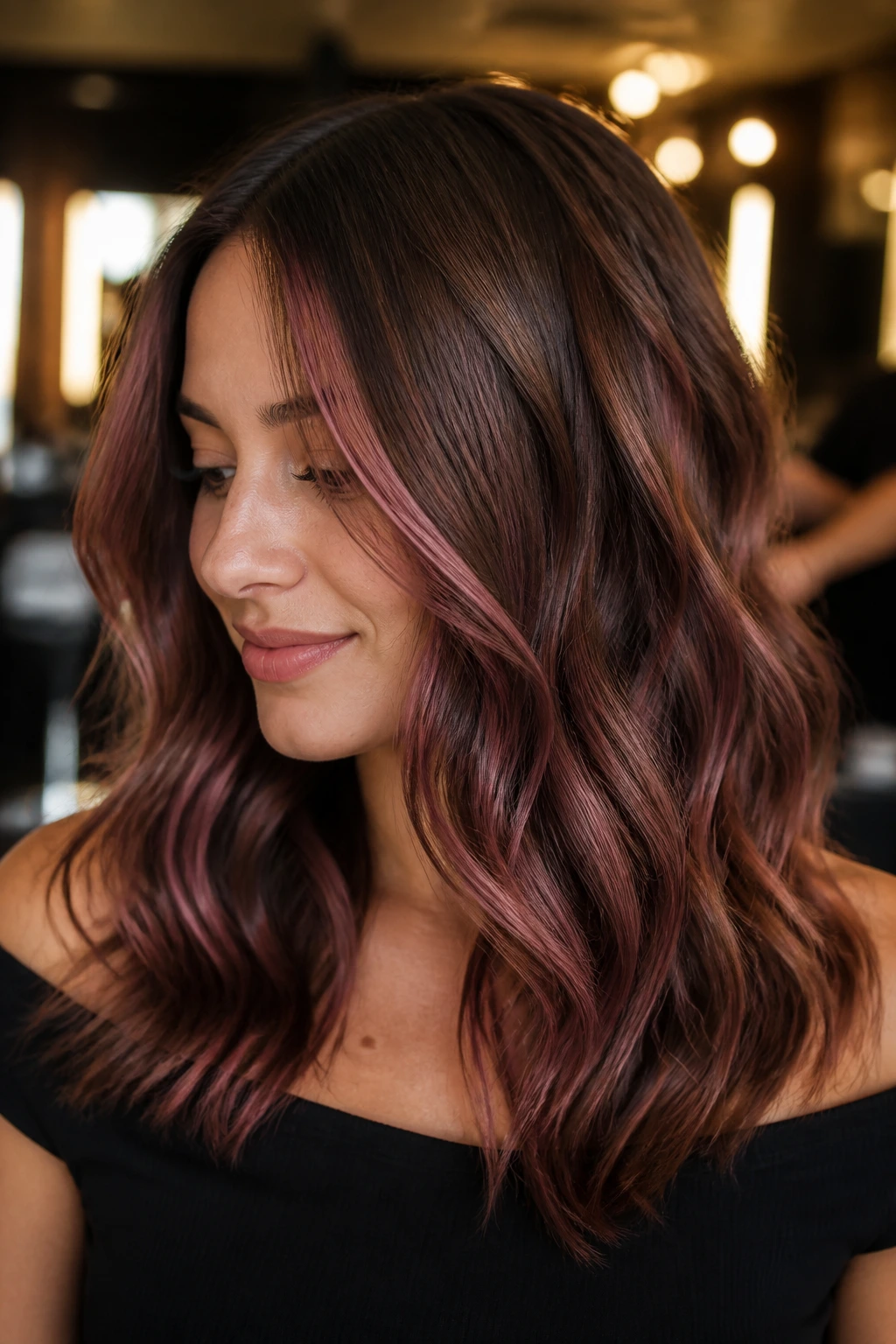 Chestnut brown hair with dusty rose-burgundy highlights in a salon