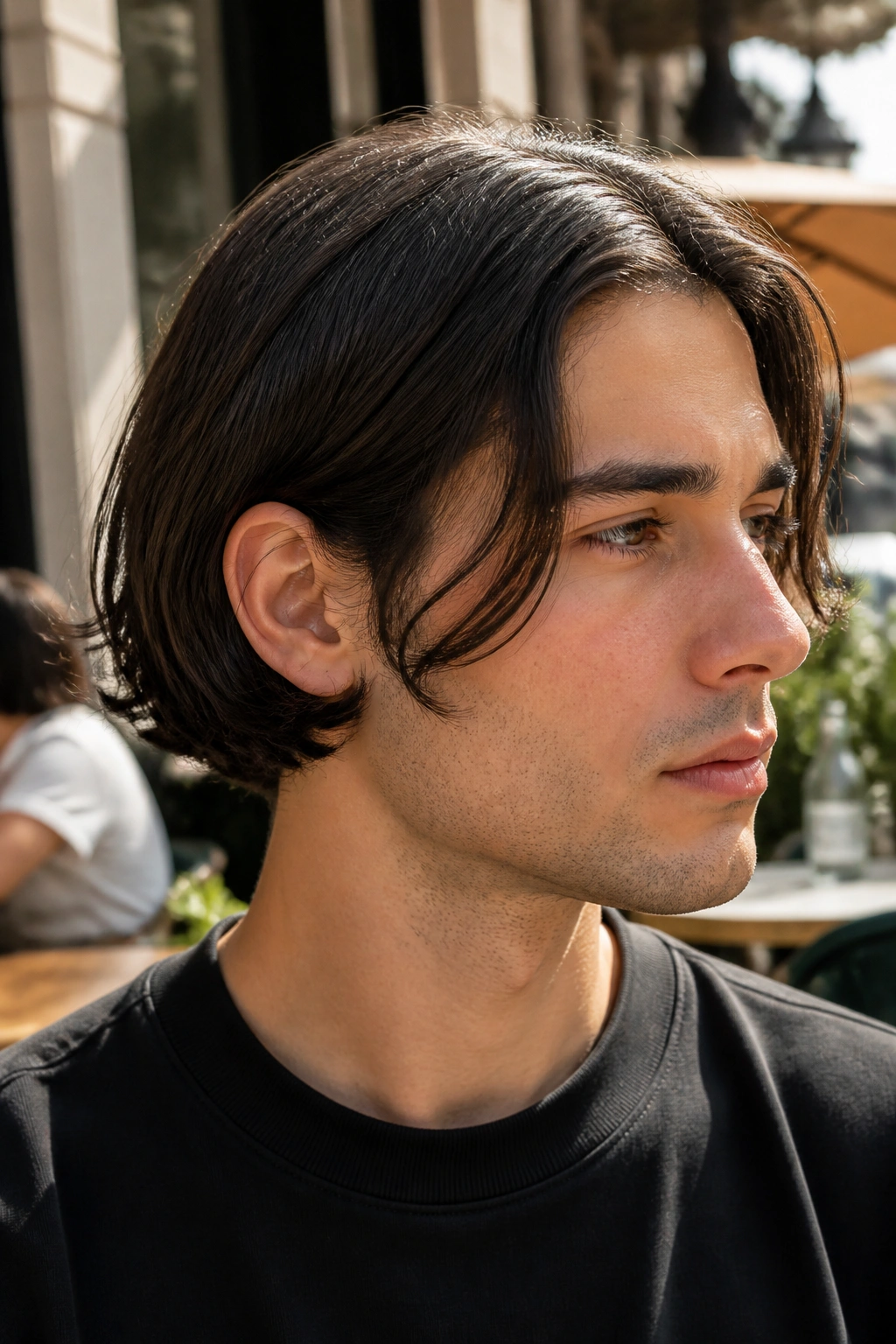 Profile view of a man with an ear-grazing bob around the ear line