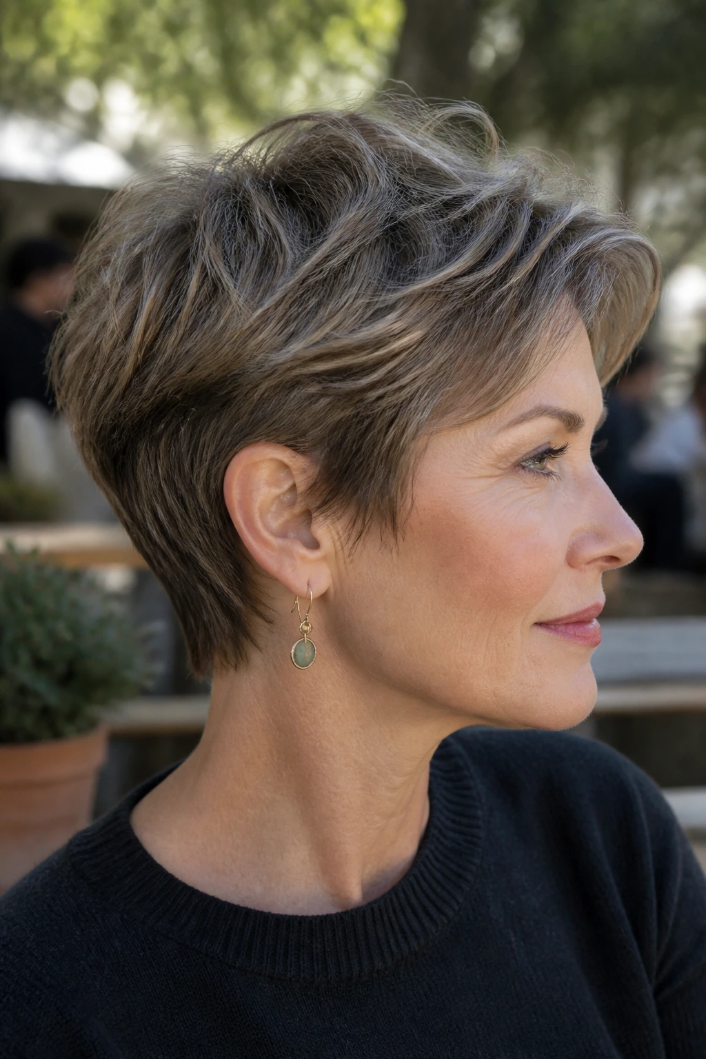 Side-profile of a real woman with ear-grazing pixie texture hairstyle