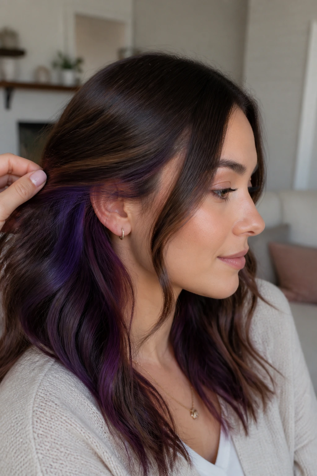 Close-up of brunette hair with eggplant underlayers peeking from behind the ear