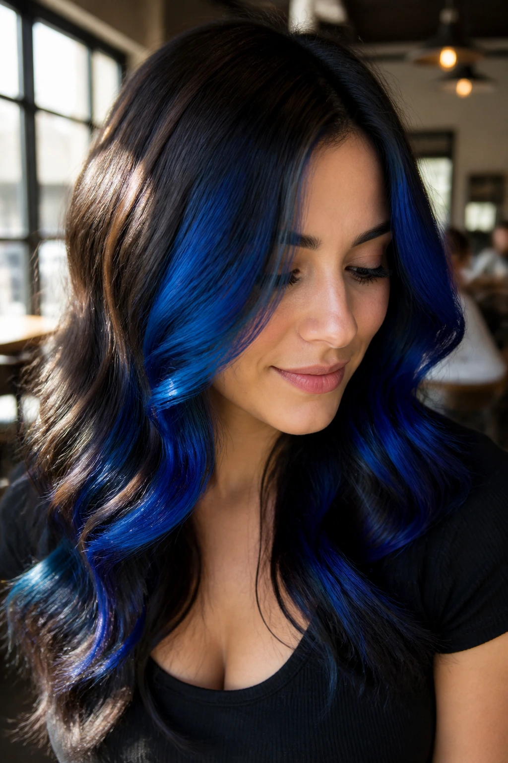 Close-up of chocolate brown hair with electric cobalt balayage for high contrast.