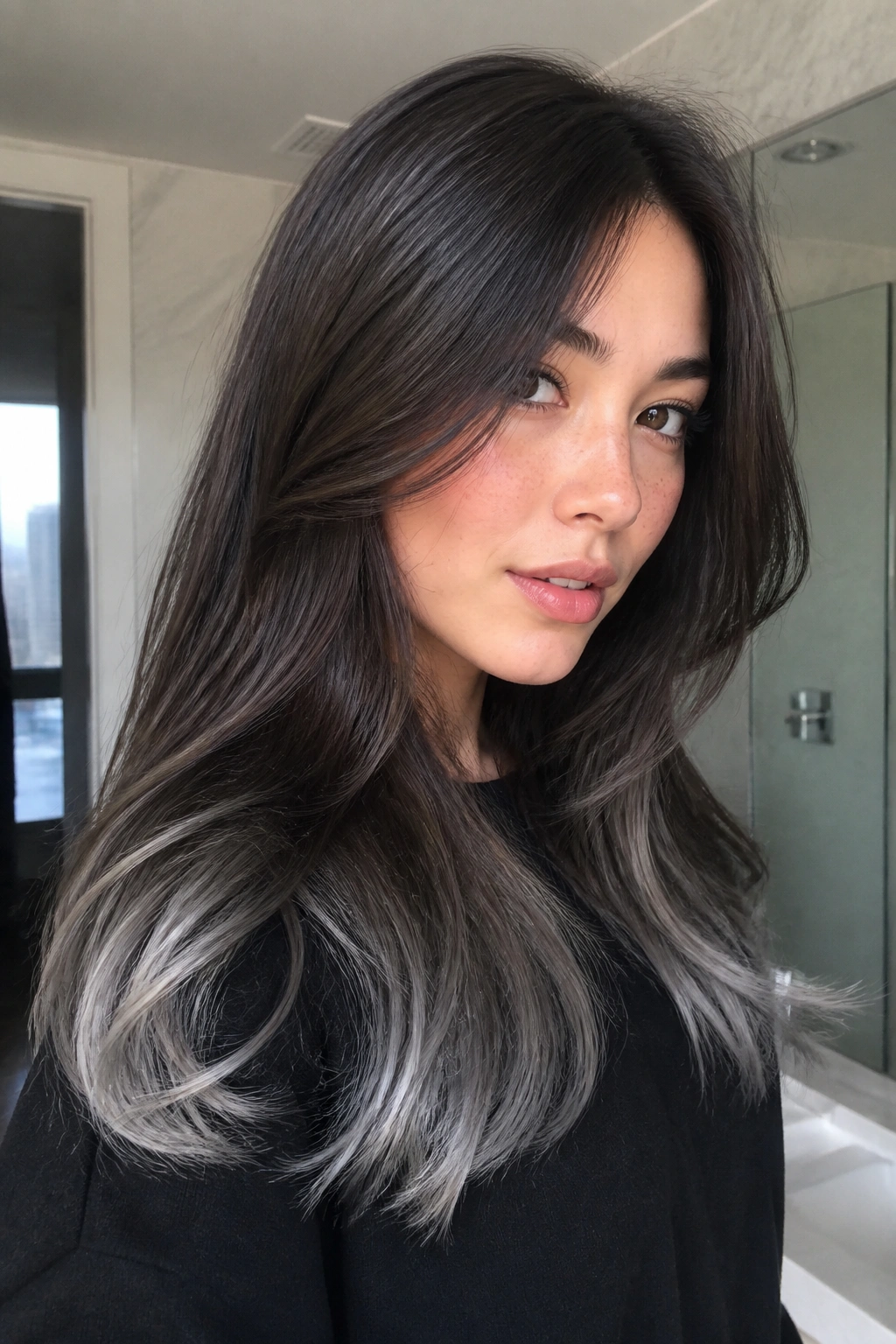 Close-up of real woman with espresso hair and silver-soft tips, natural window light.
