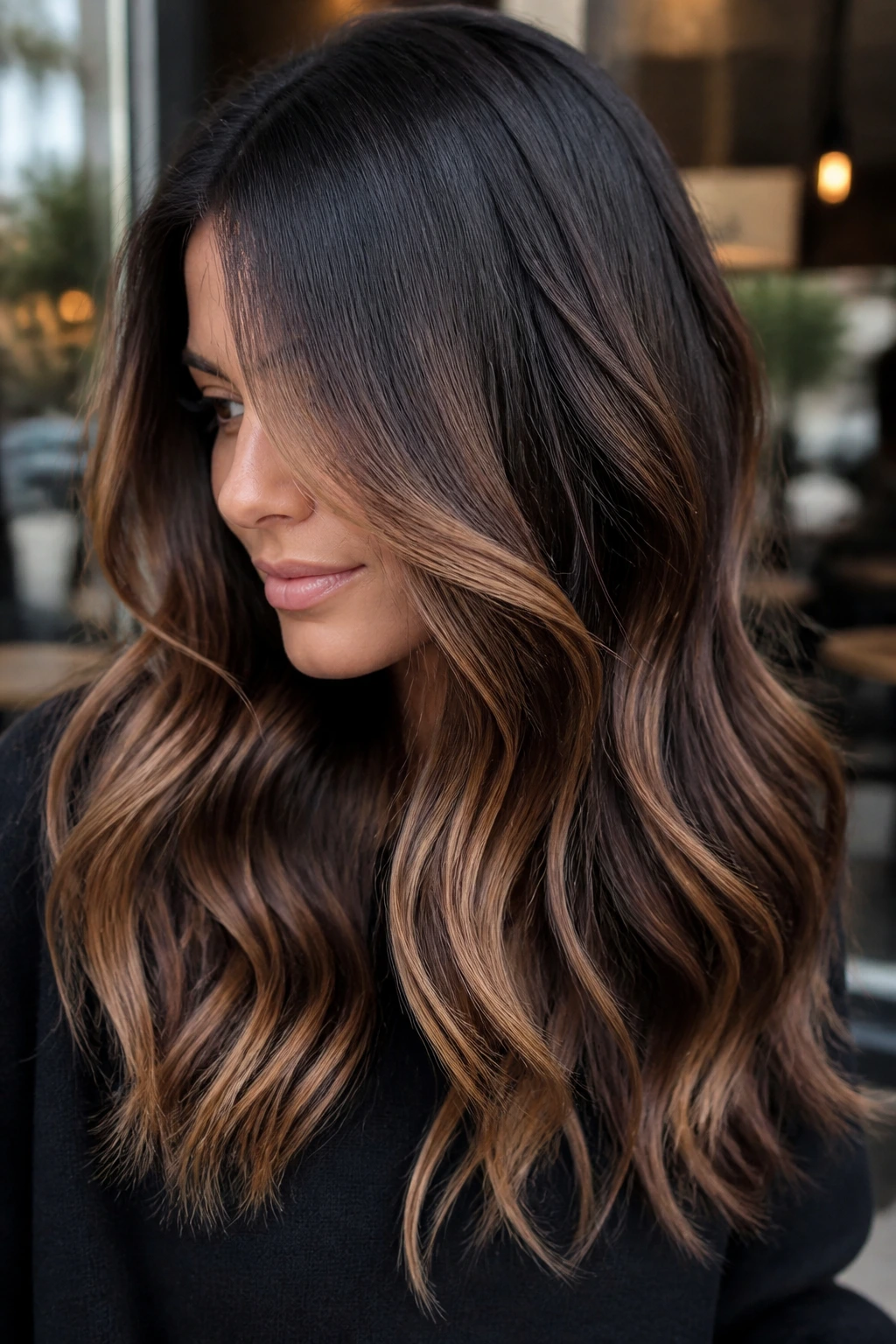 Close-up portrait of a real woman with espresso and toffee balayage in high-contrast brunette.