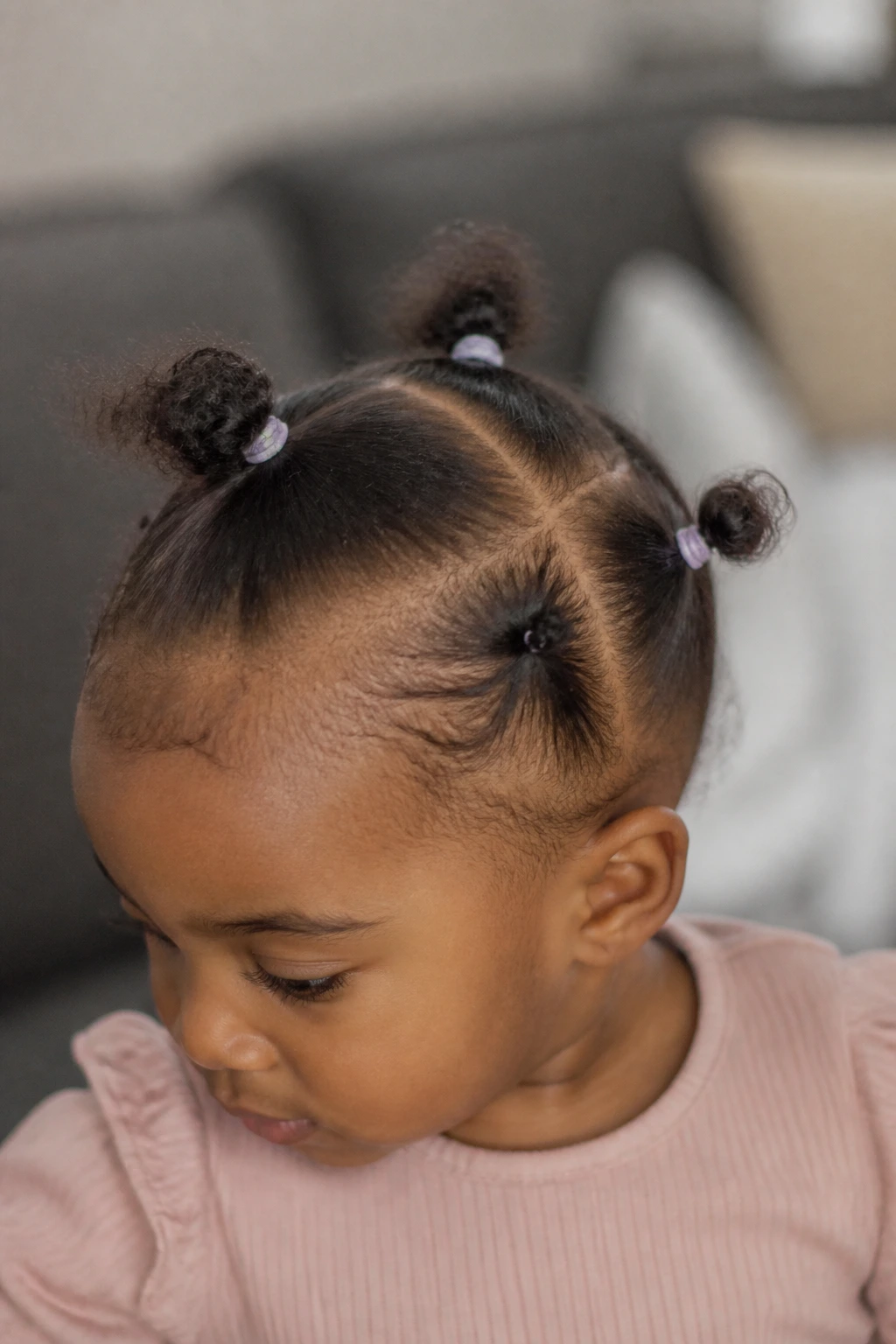 Close-up of a toddler's head showing four tiny ponytails