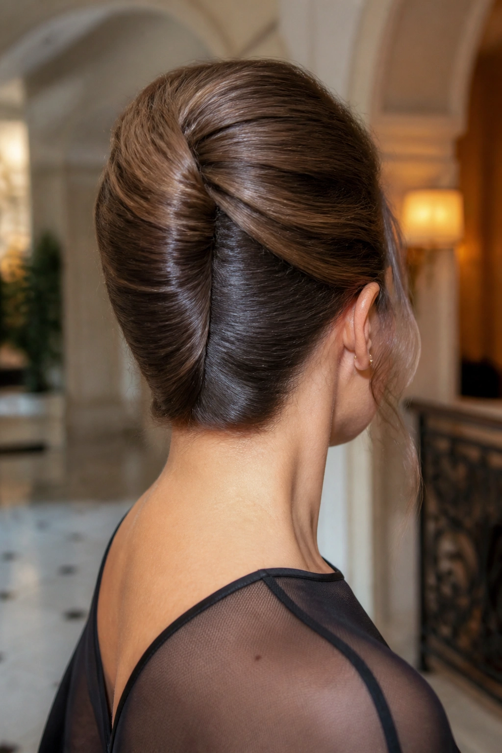 Close-up of a real woman with a French twist updo in a softly lit room