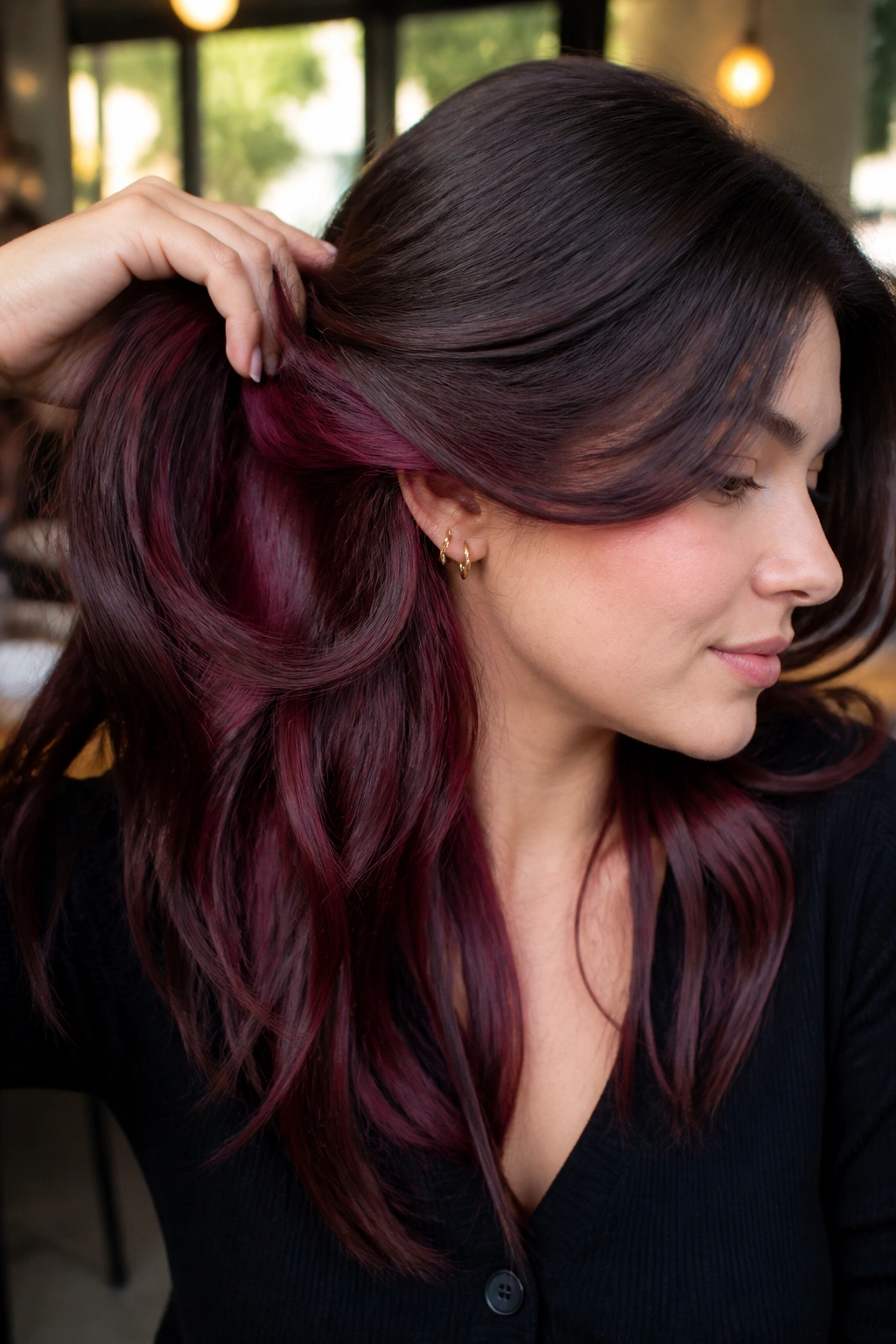 Brunette with garnet underlayers peeking from beneath the hair near the nape