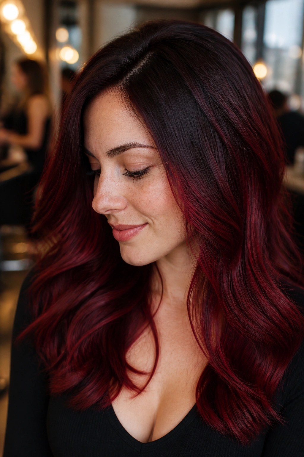 Close-up portrait of a real woman with garnet shadow root color; soft transition without harsh line