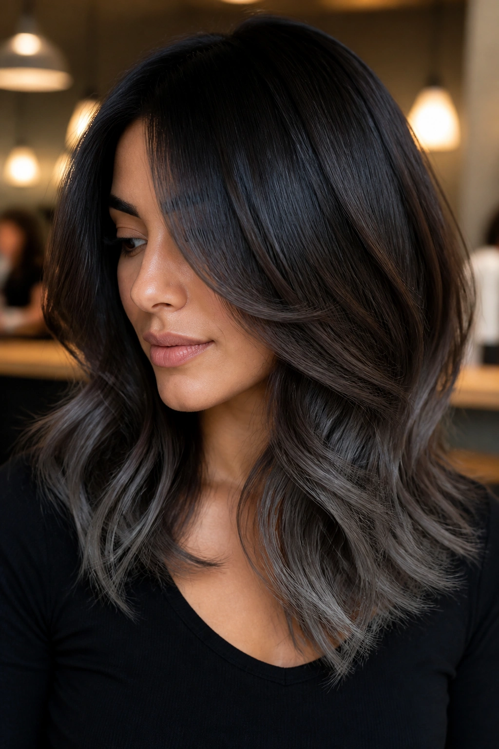 Close-up portrait of a real person with graphite ends on layered dark brown hair