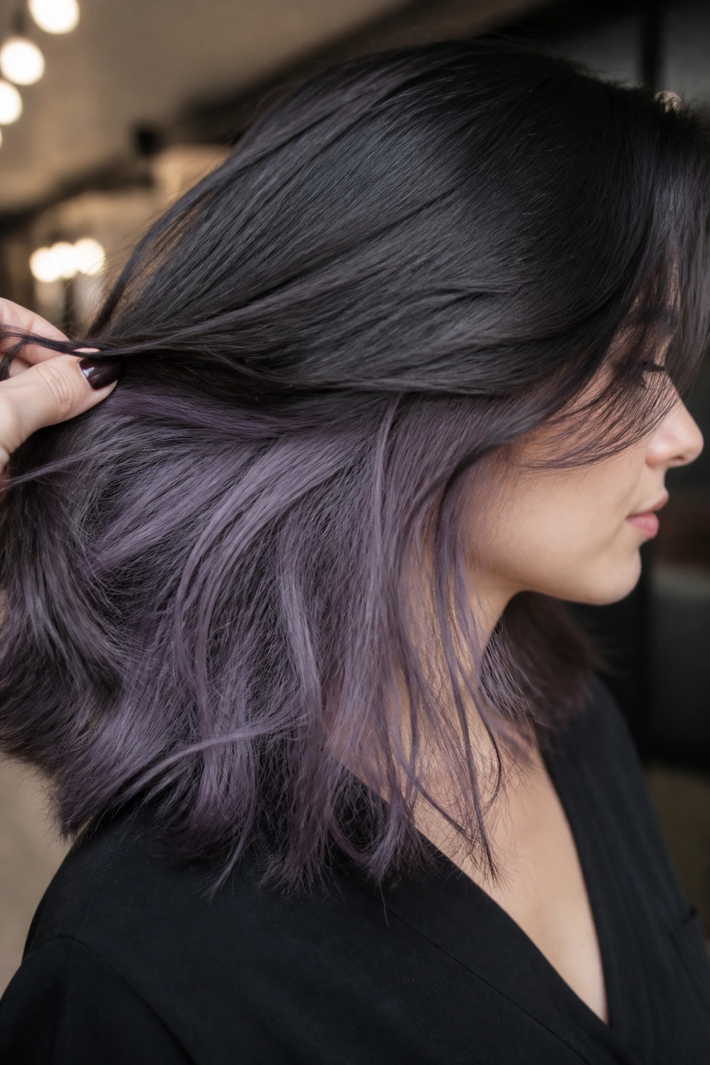 Close-up portrait of a real person with graphite lilac underlayer hair.