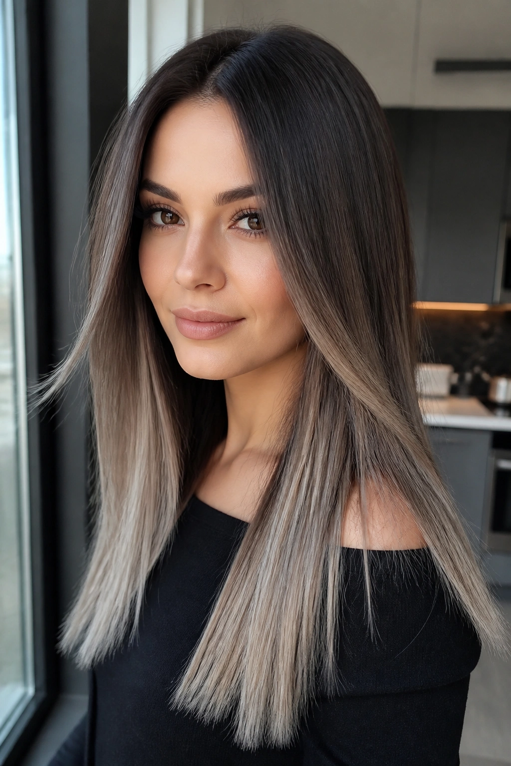 Close-up of a woman with gray melt balayage on straight brown hair under natural light.