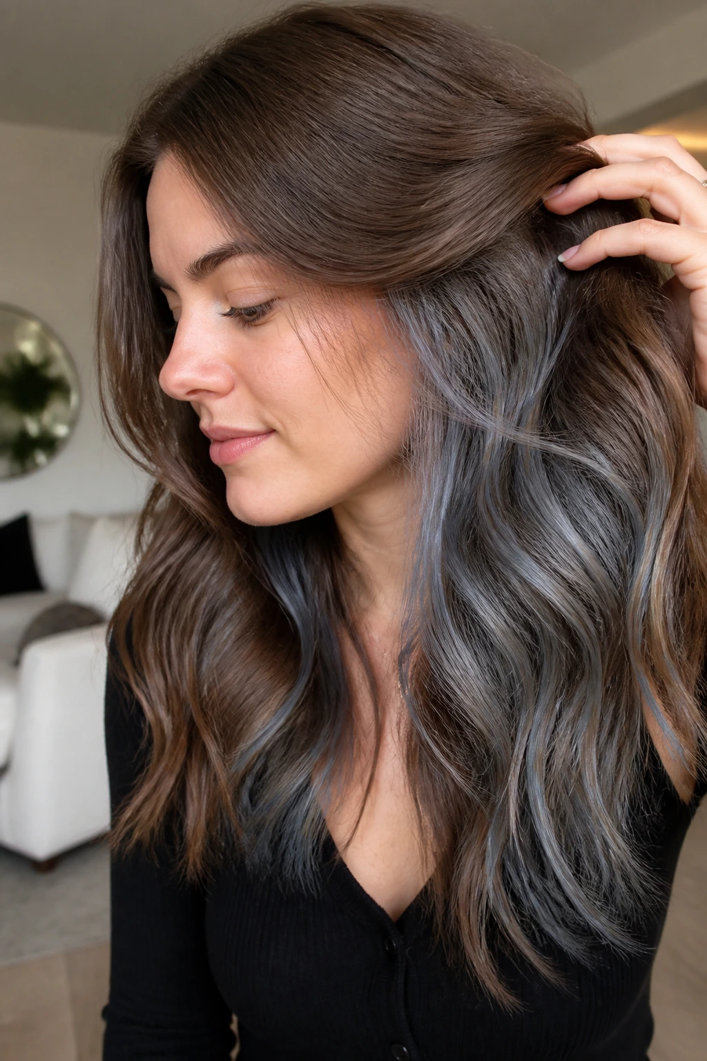 Close-up of brunette with grey underlights peeking through brown hair.