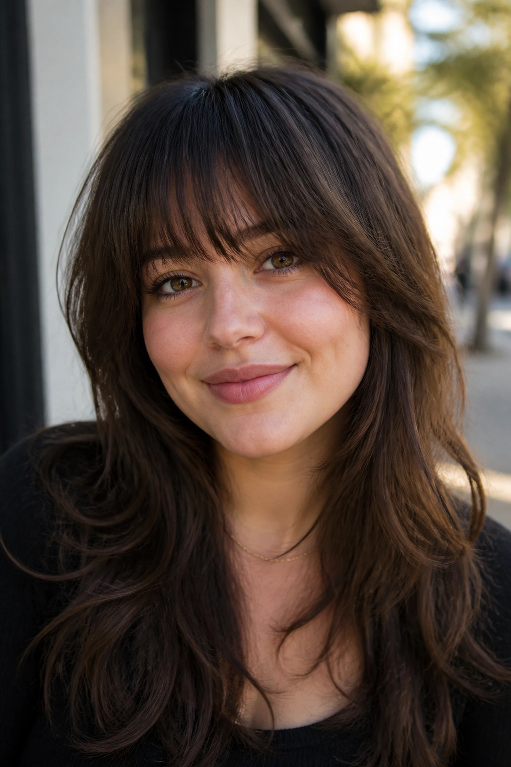 Close-up portrait of a real woman with thick hair and feathered bangs outdoors