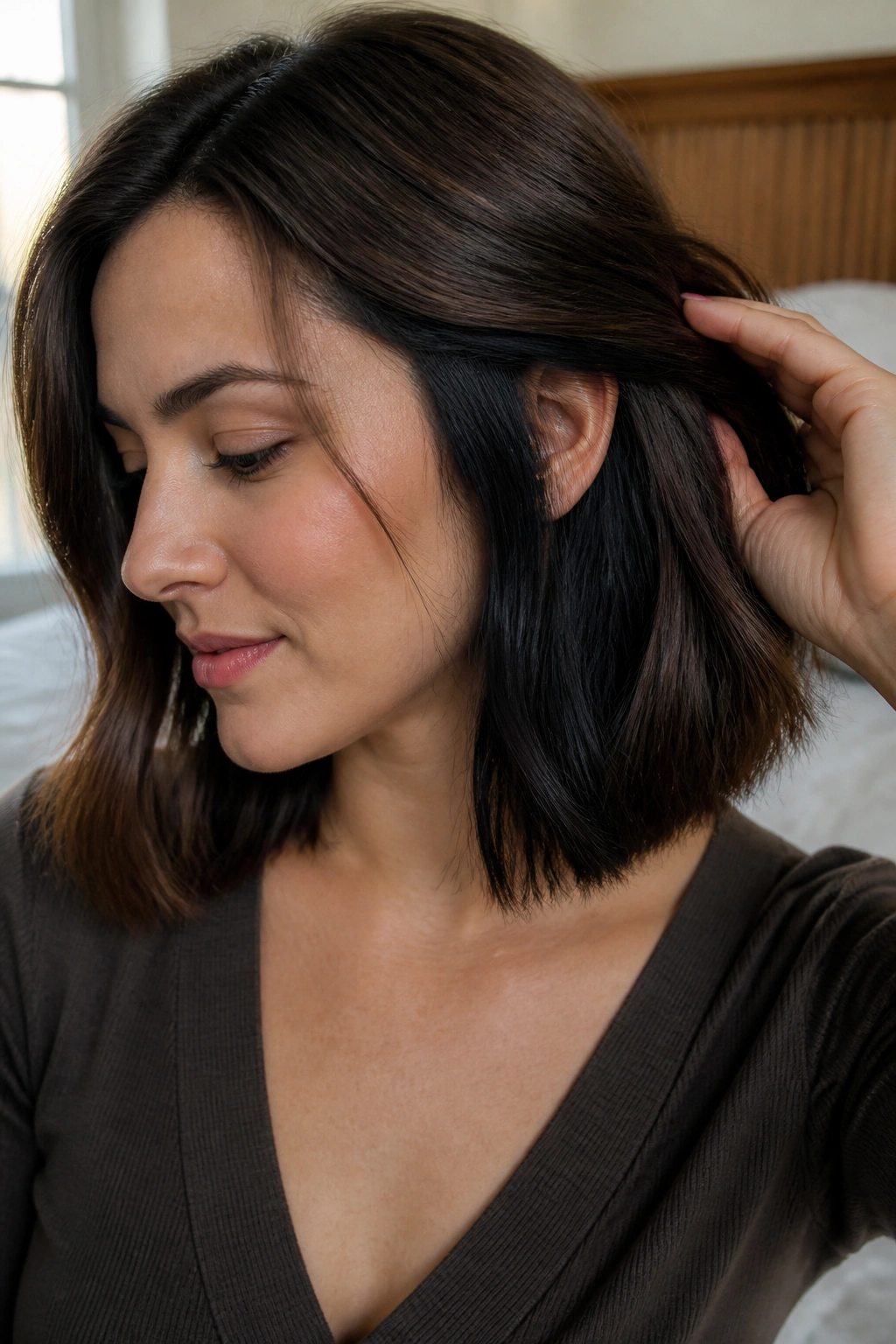 Close-up of a real woman showing hidden black panels under a brown lob with ear tucked.