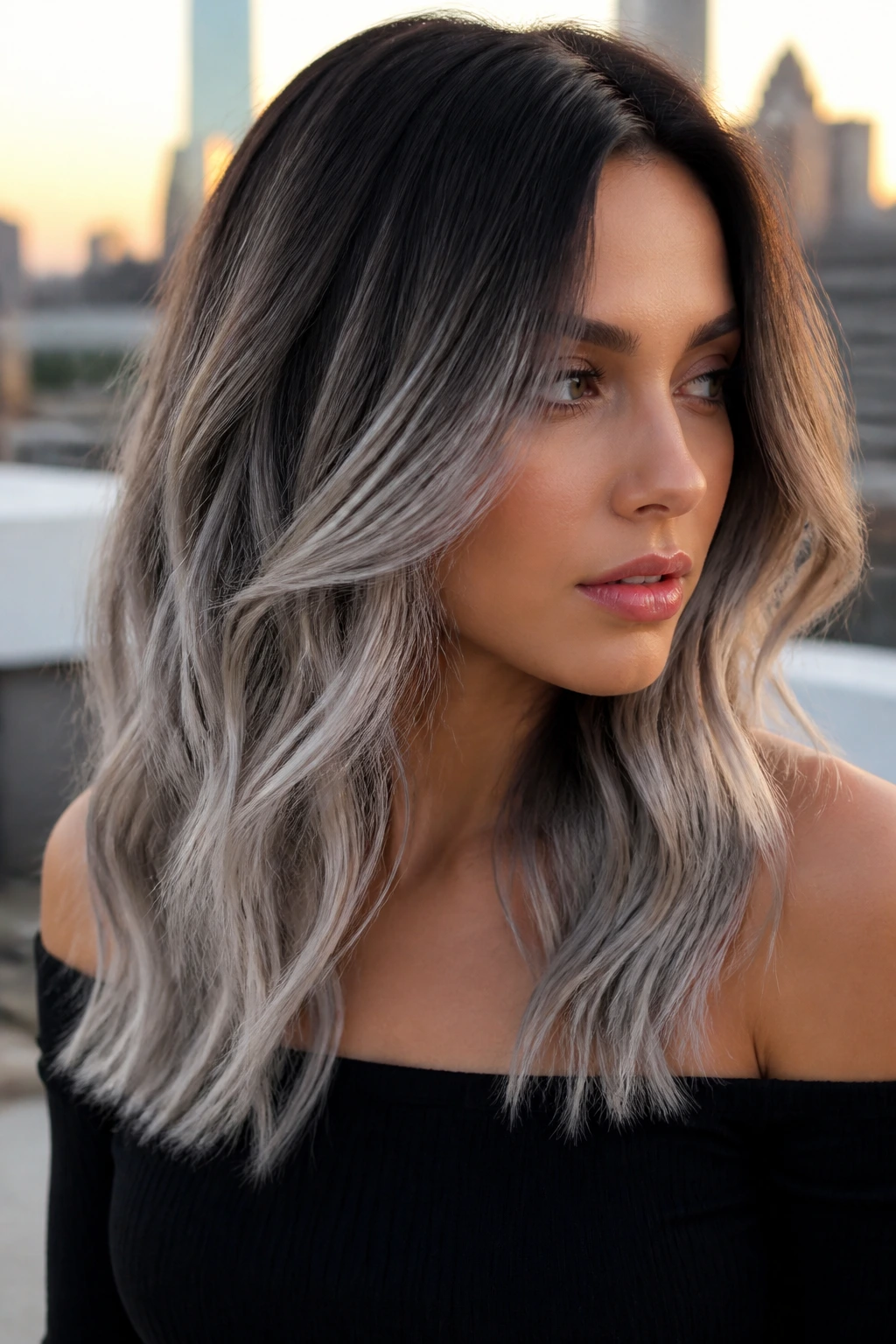 Close-up portrait of a real woman with dark roots and silvery ash ends in golden hour light.
