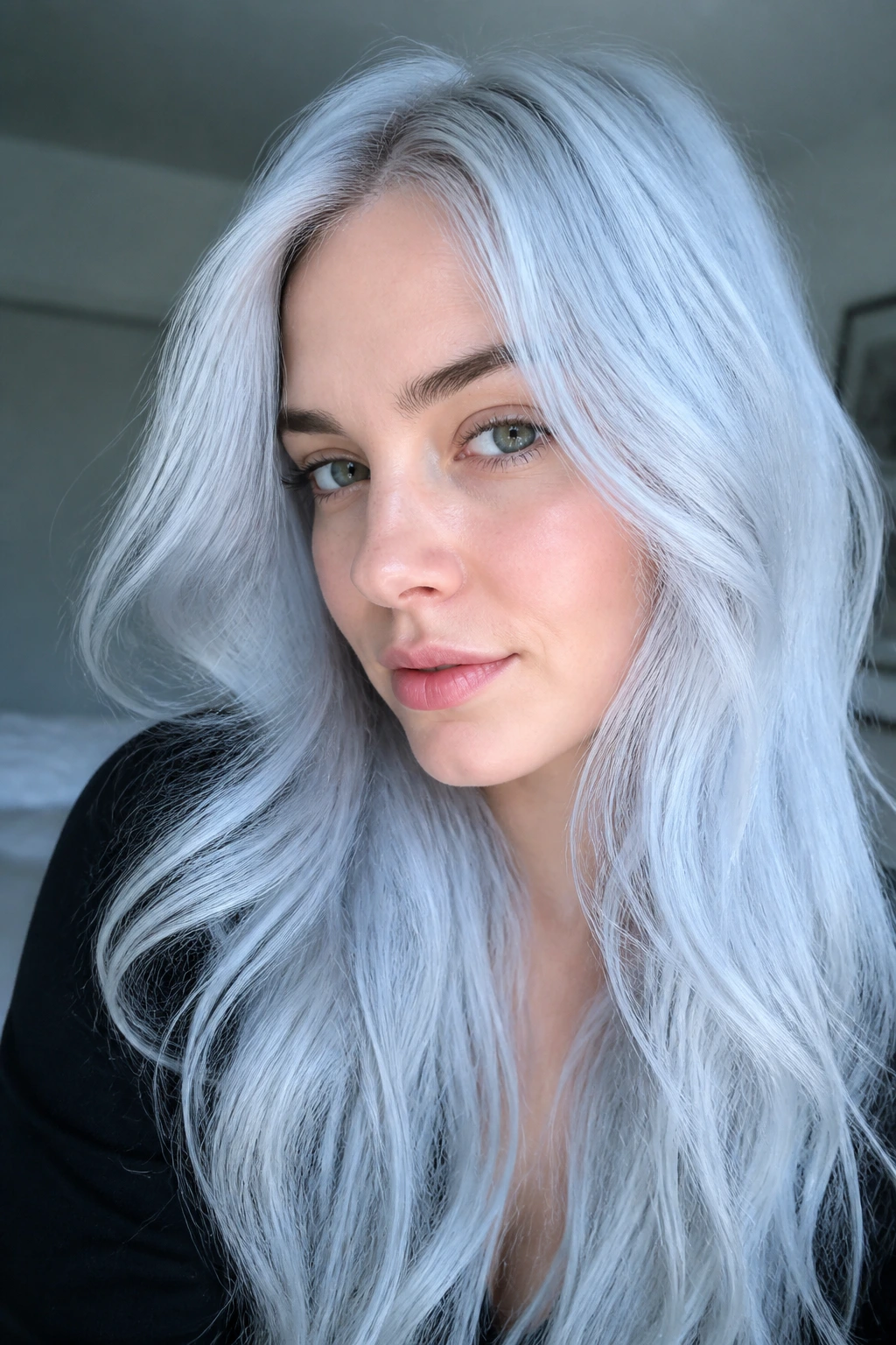 Close-up portrait of a woman with icy platinum blue hair under cool window light.