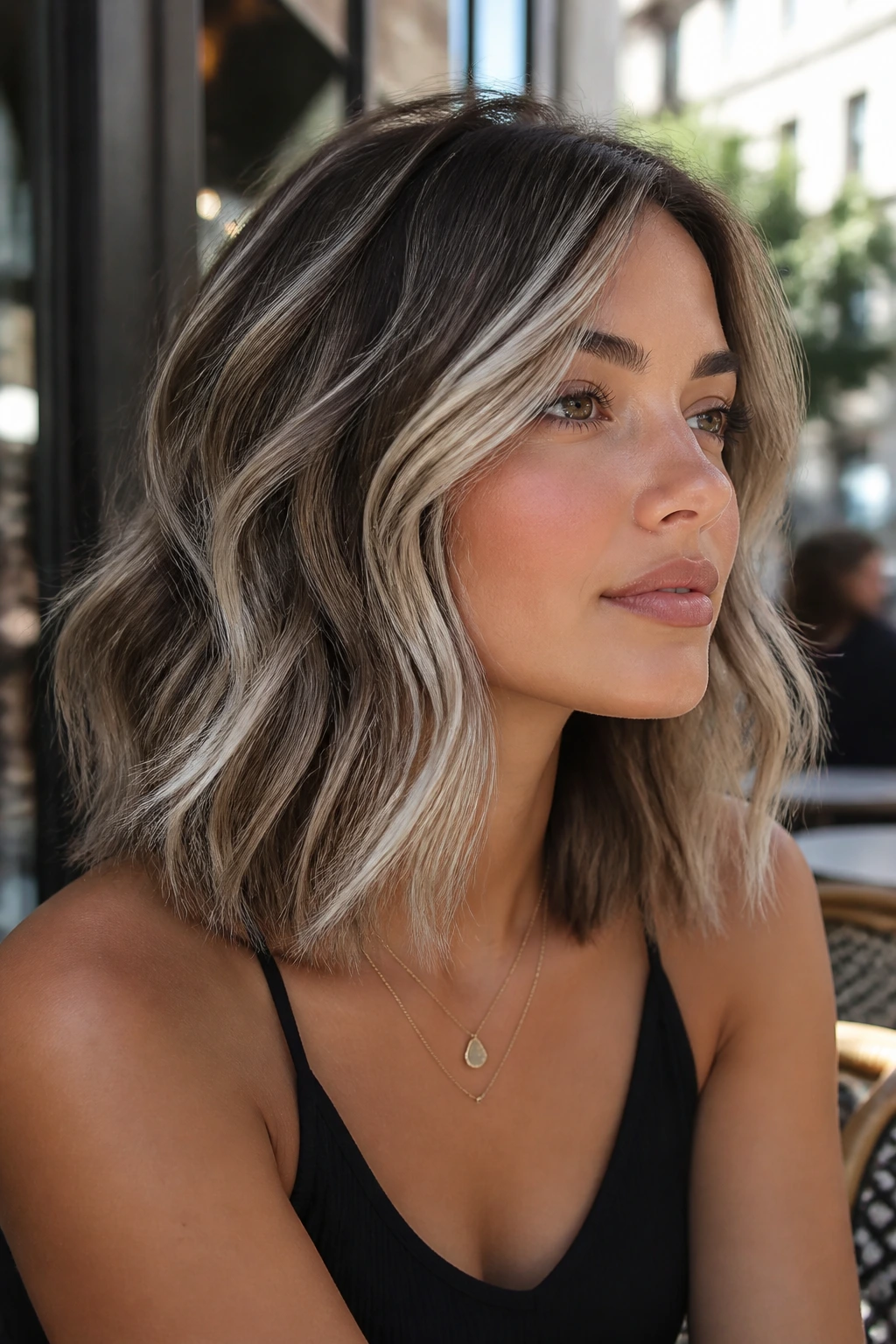 Wavy lob hairstyle with scattered icy platinum threads on real person.