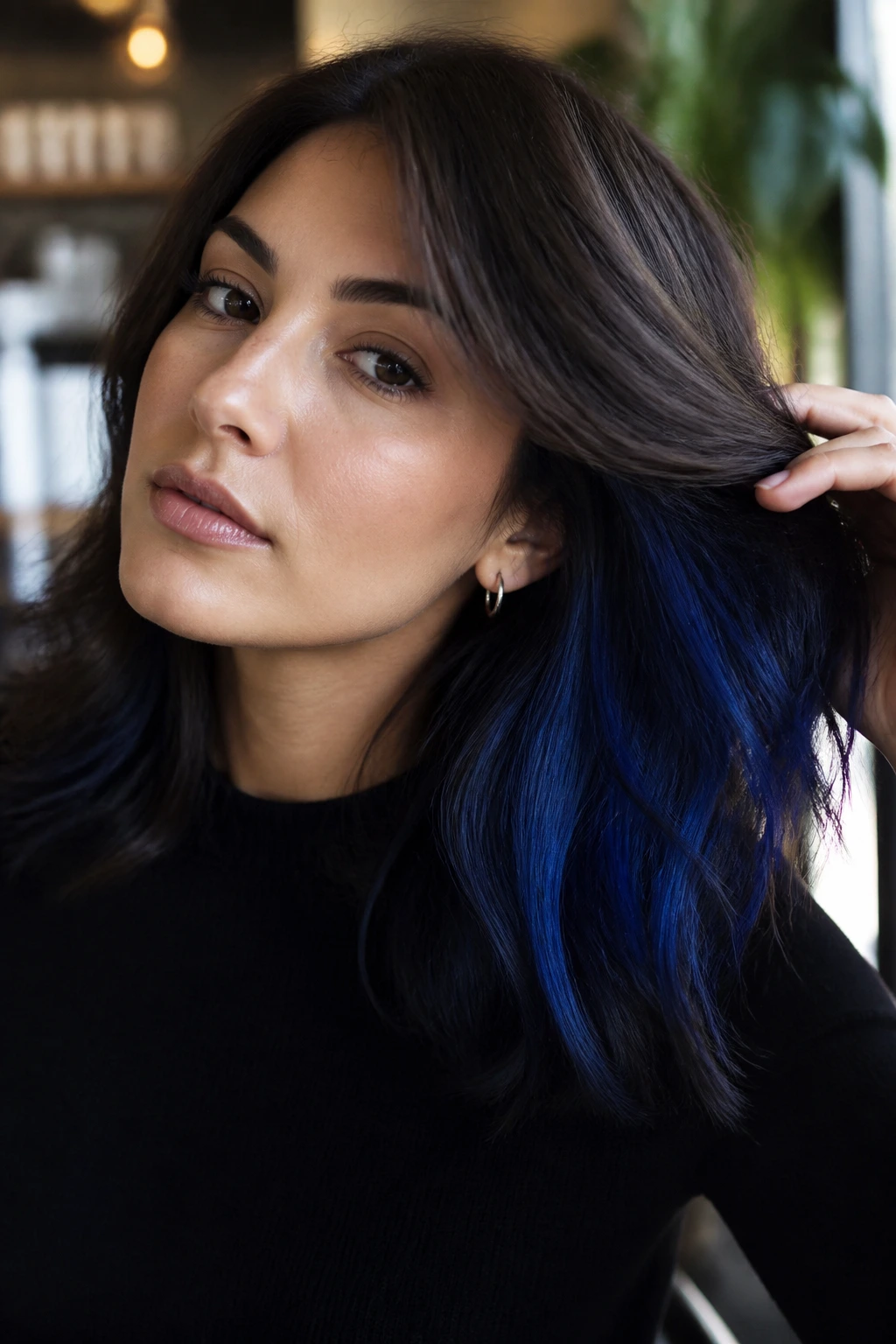 Close-up of a real woman showing ink blue underlayer peeking through brunette hair