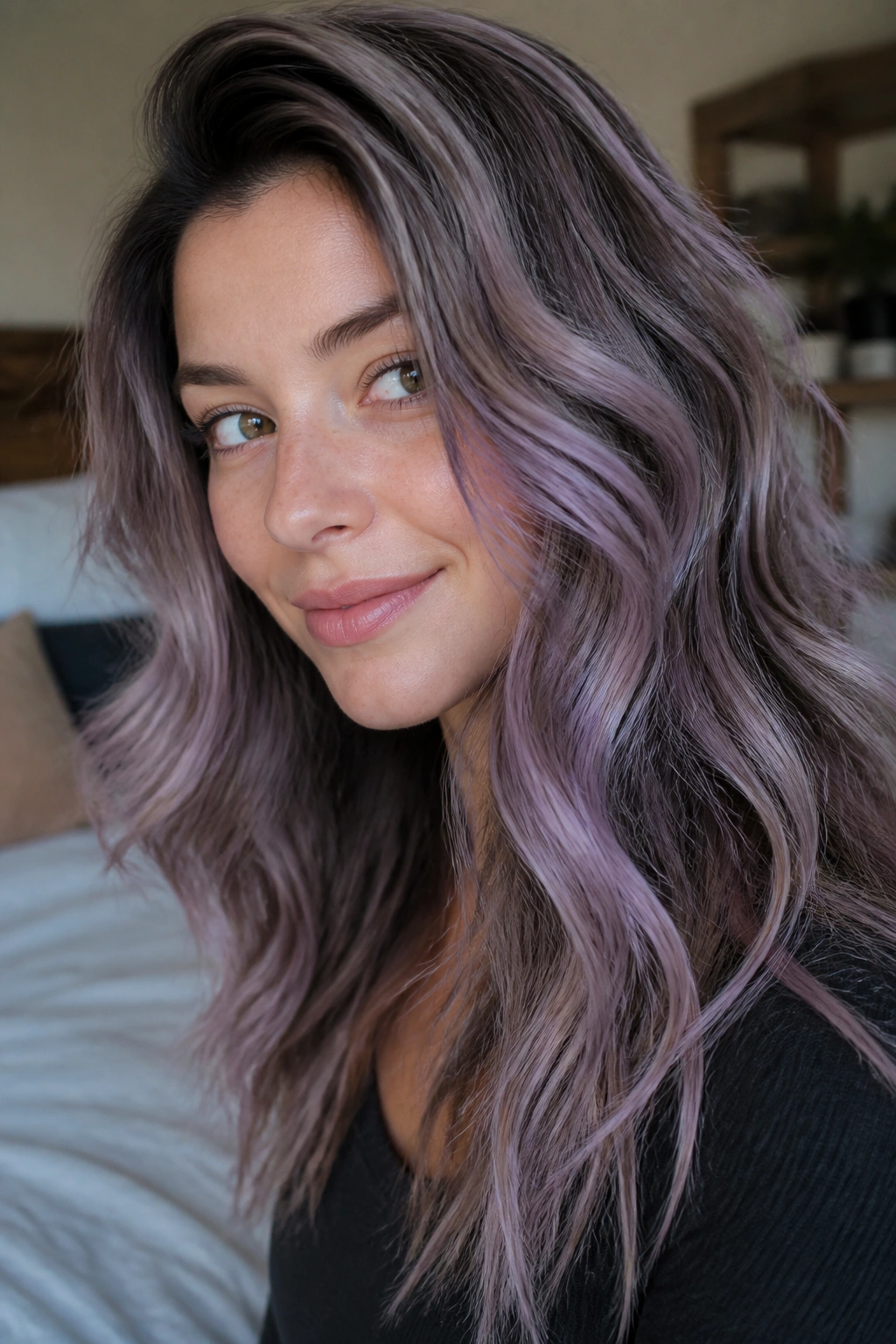 Close-up of a real woman's hair showing a cool lavender veil balayage on brown hair in soft window light