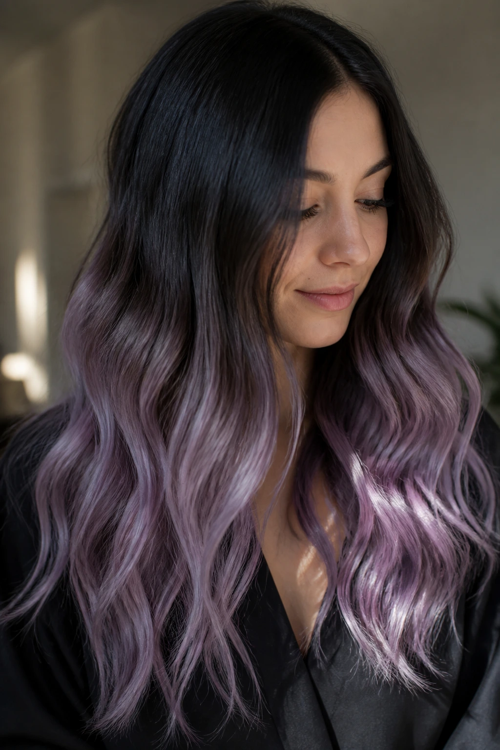 Close-up of a real woman's long hair showing black to lavender smoke ends ombre, with soft waves.