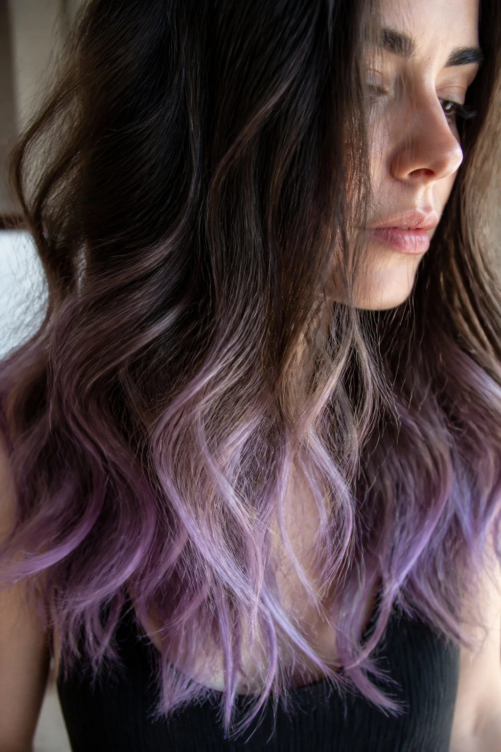 Close-up of wavy brunette hair with lavender tips at the ends