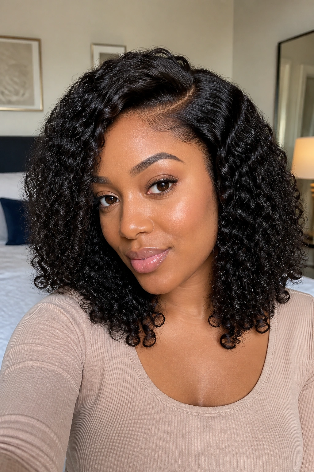 Real person wearing layered curly wig with off-center part, curls cascade past the chin