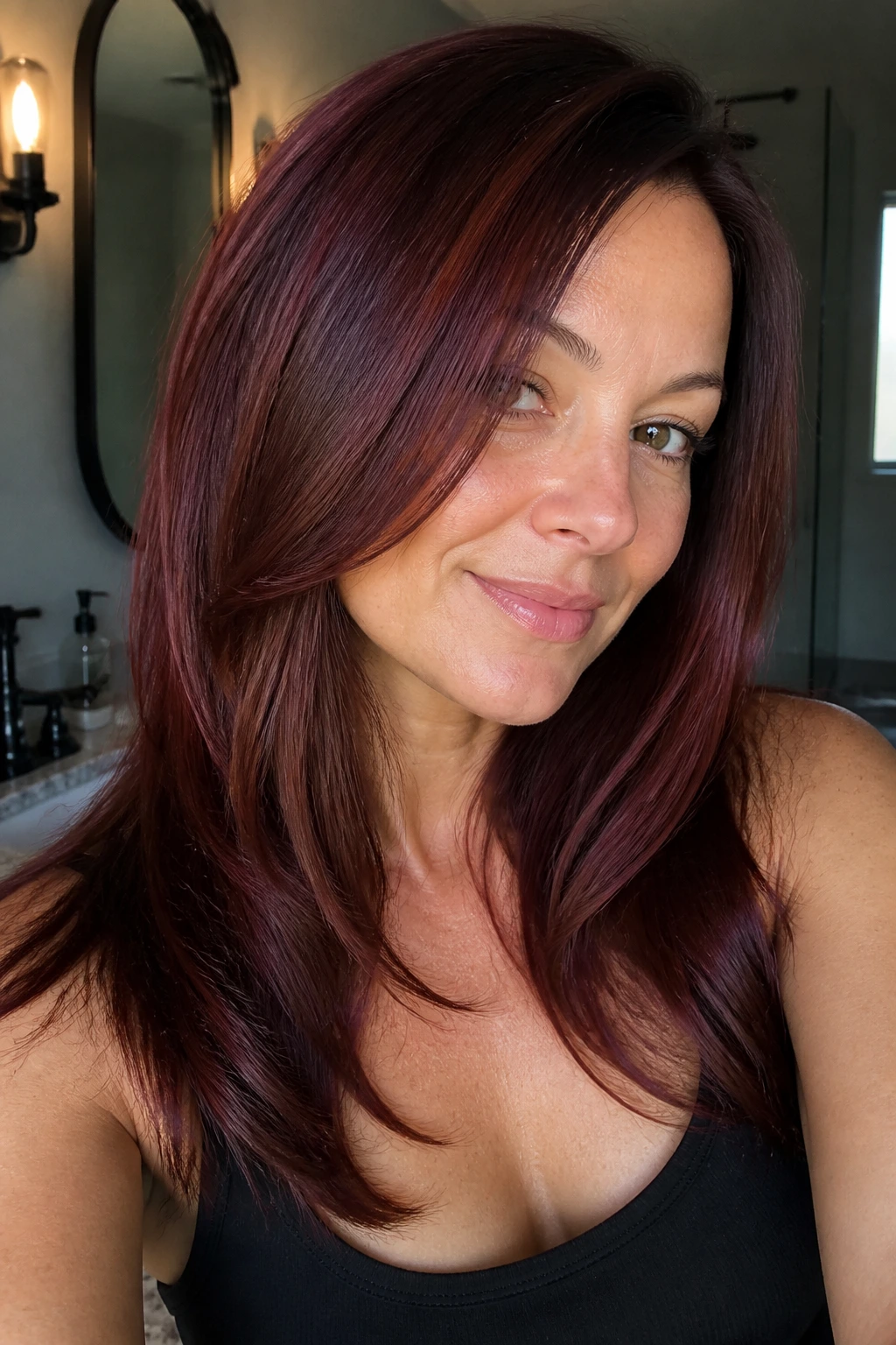 Close-up of a real woman with faded red hair revived by mahogany gloss